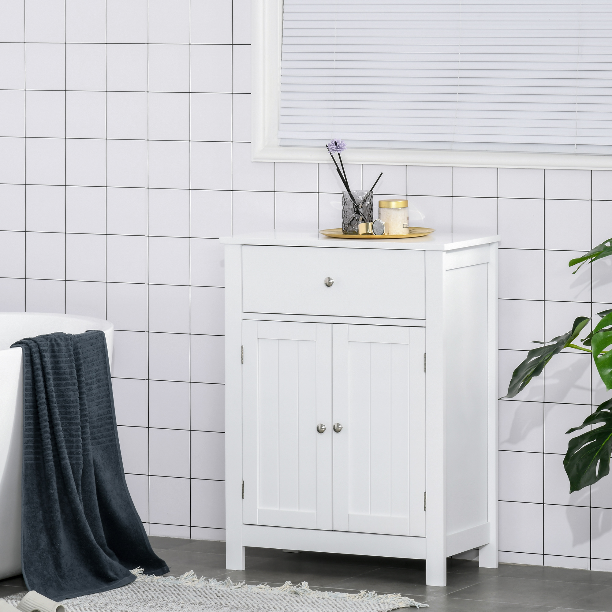Un mueble de baño blanco con cajón y doble puerta se asienta sobre un suelo alicatado.