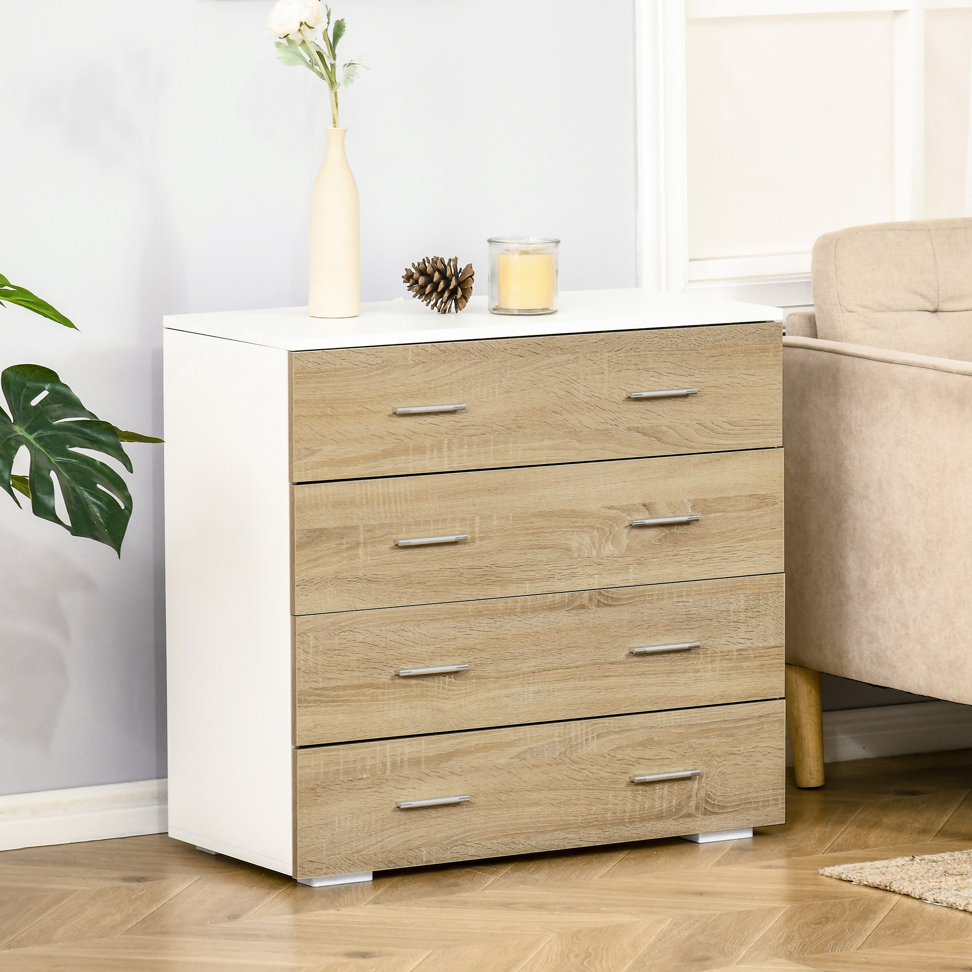 Cómoda blanca con cuatro cajones de aspecto madera, decorada con jarrón, piña y vela.