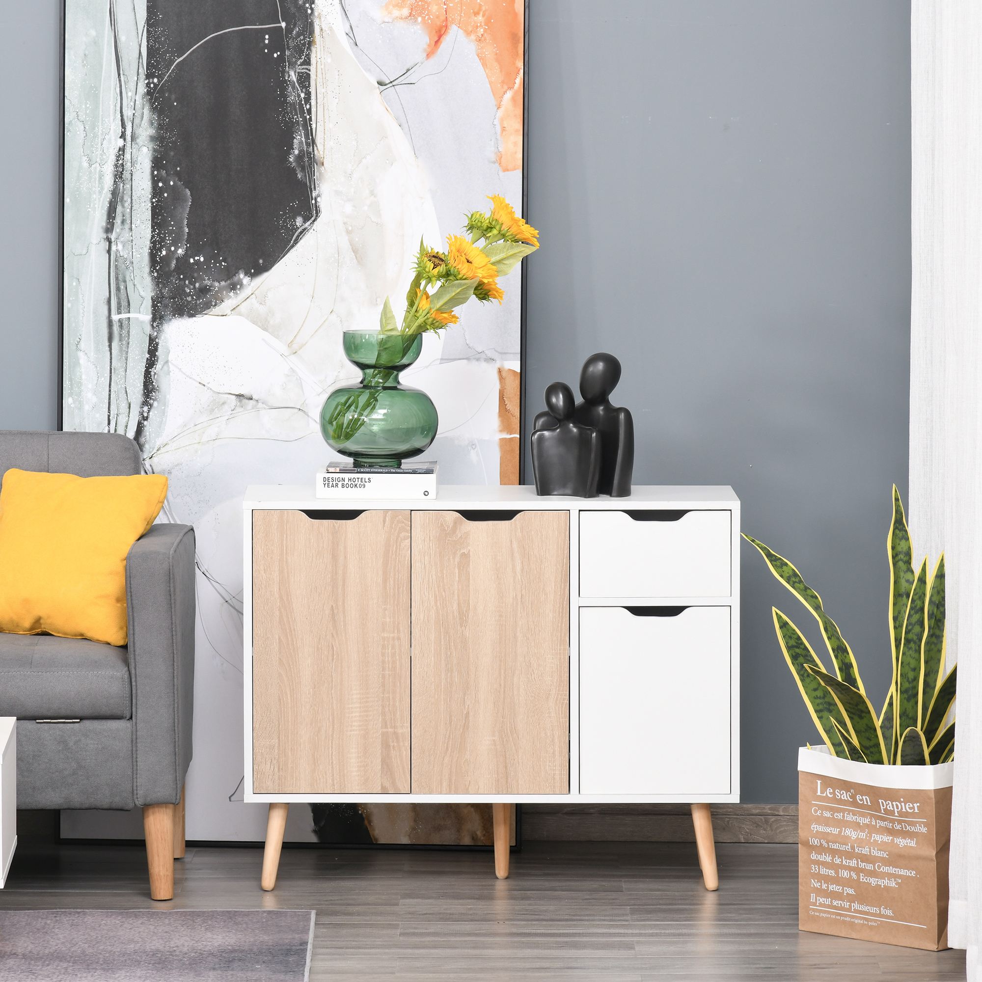 Una sala de estar moderna con sofá, mueble, arte y planta.