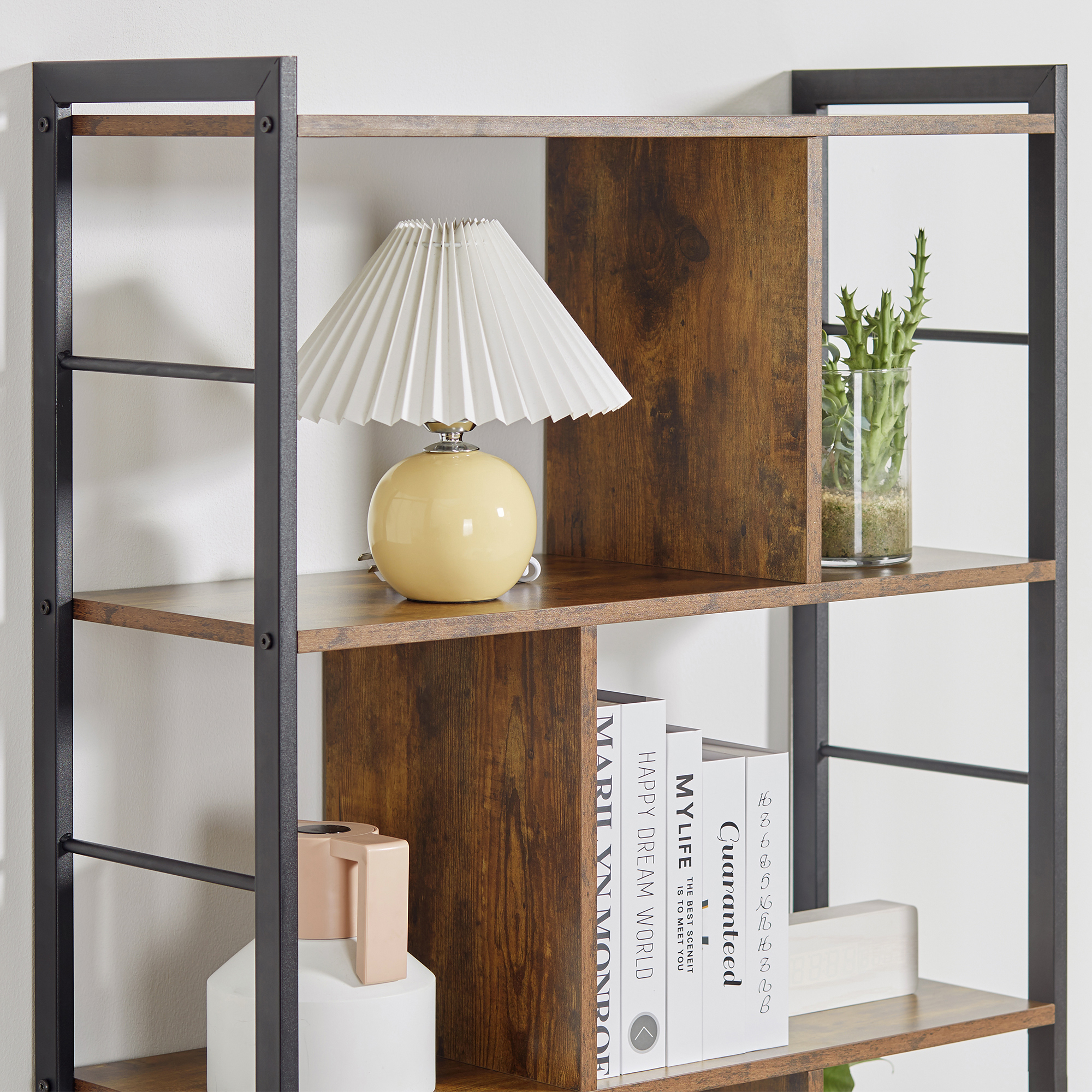 Una estantería con libros, una lámpara y una planta.