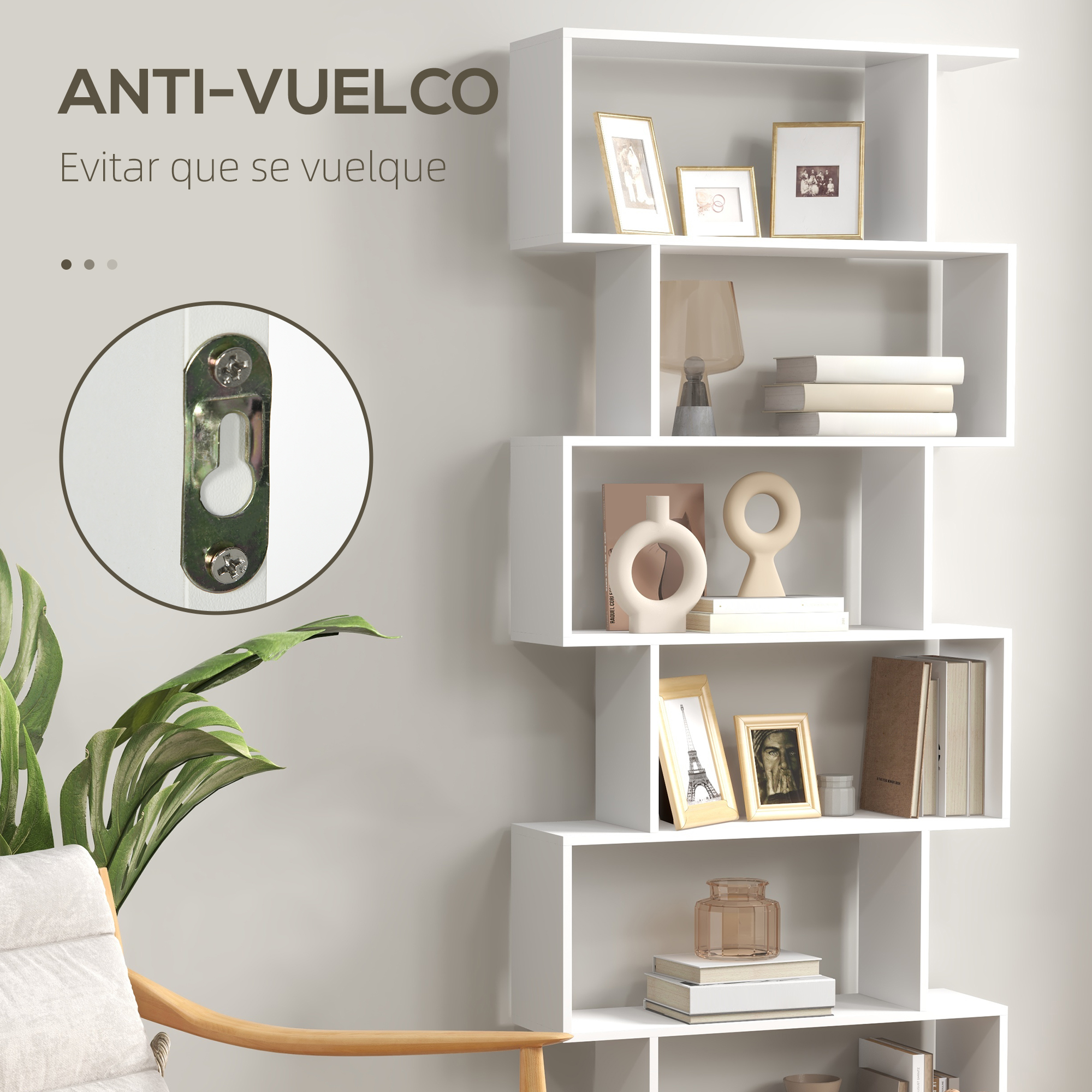 Una estantería blanca con objetos decorativos y un sillón.