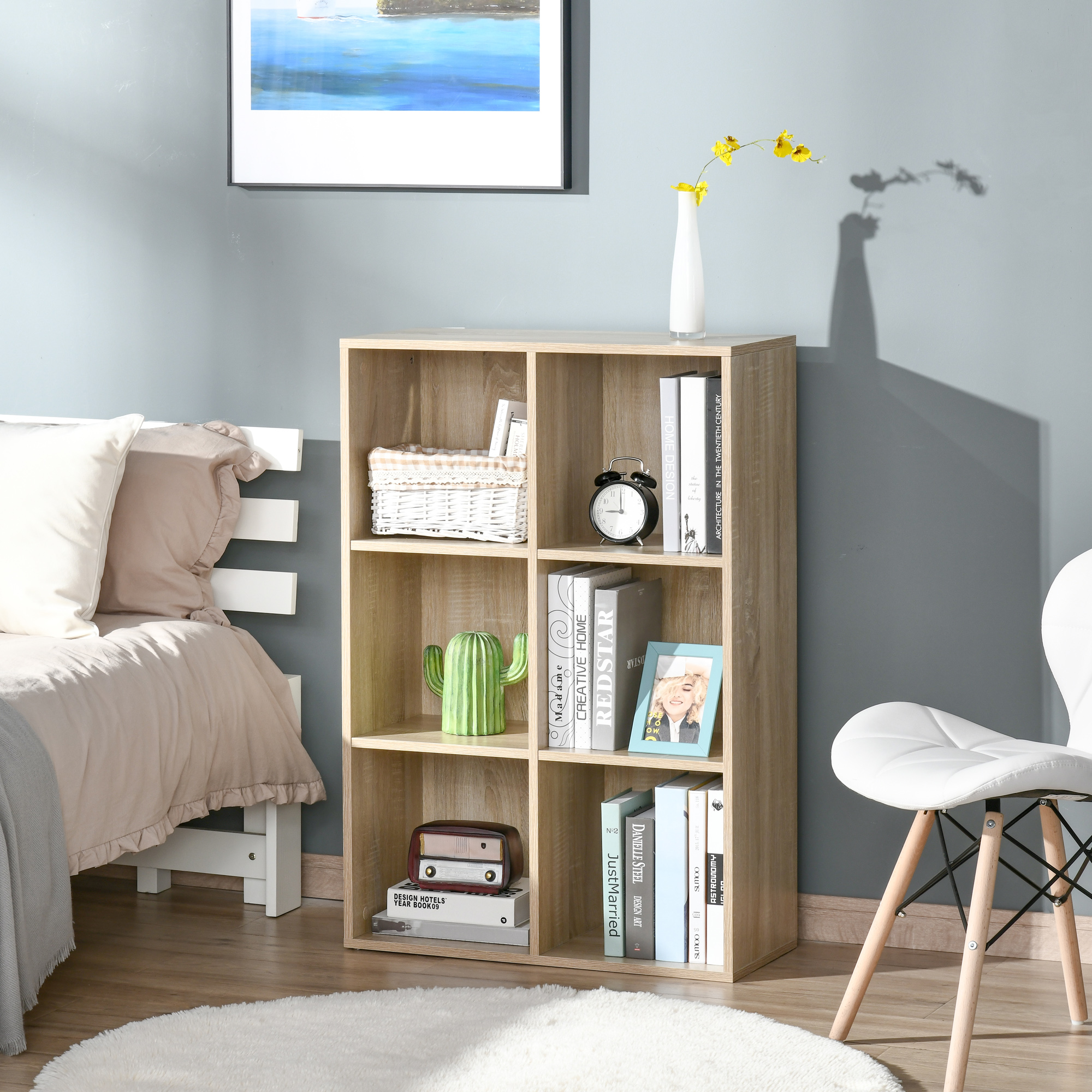 Una libreria in legno con libri, vaso, sveglia e cactus.