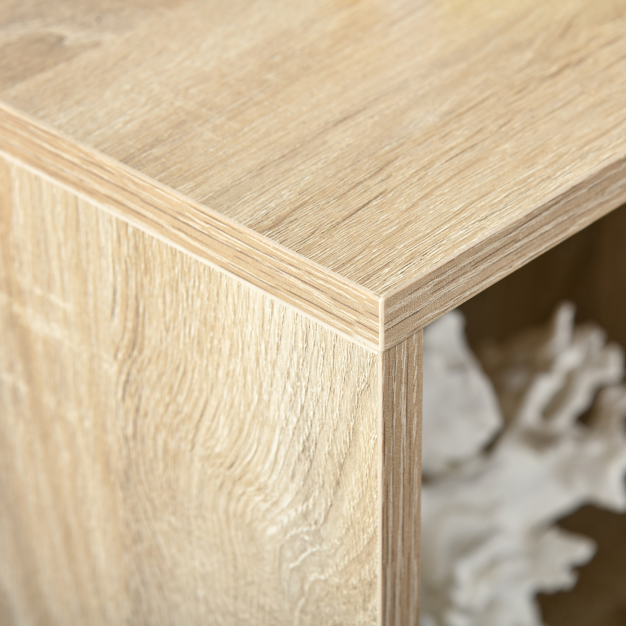 Primer plano de una superficie de madera de color marrón claro con veta visible y una esquina.