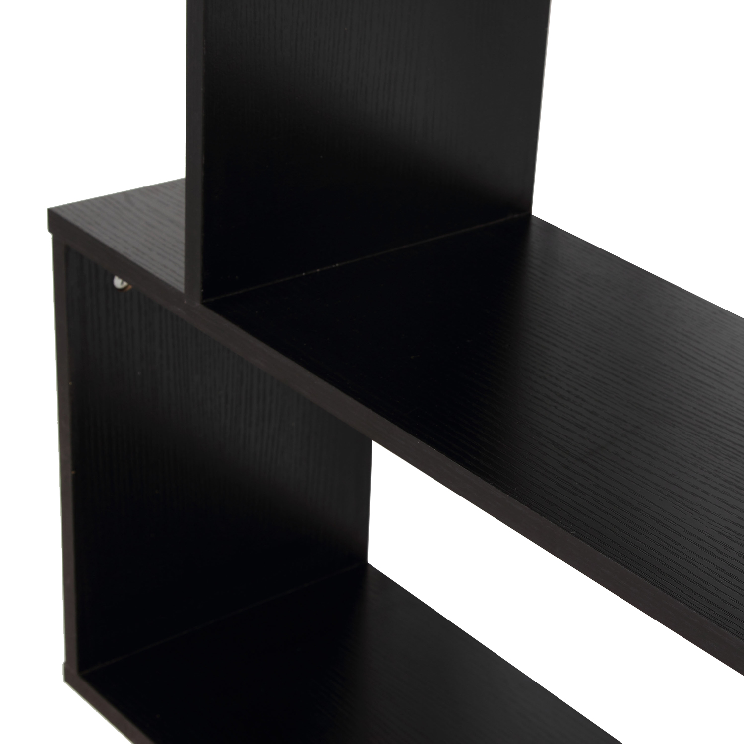 Primer plano de una estantería negra con veta de madera, bordes y soportes visibles.
