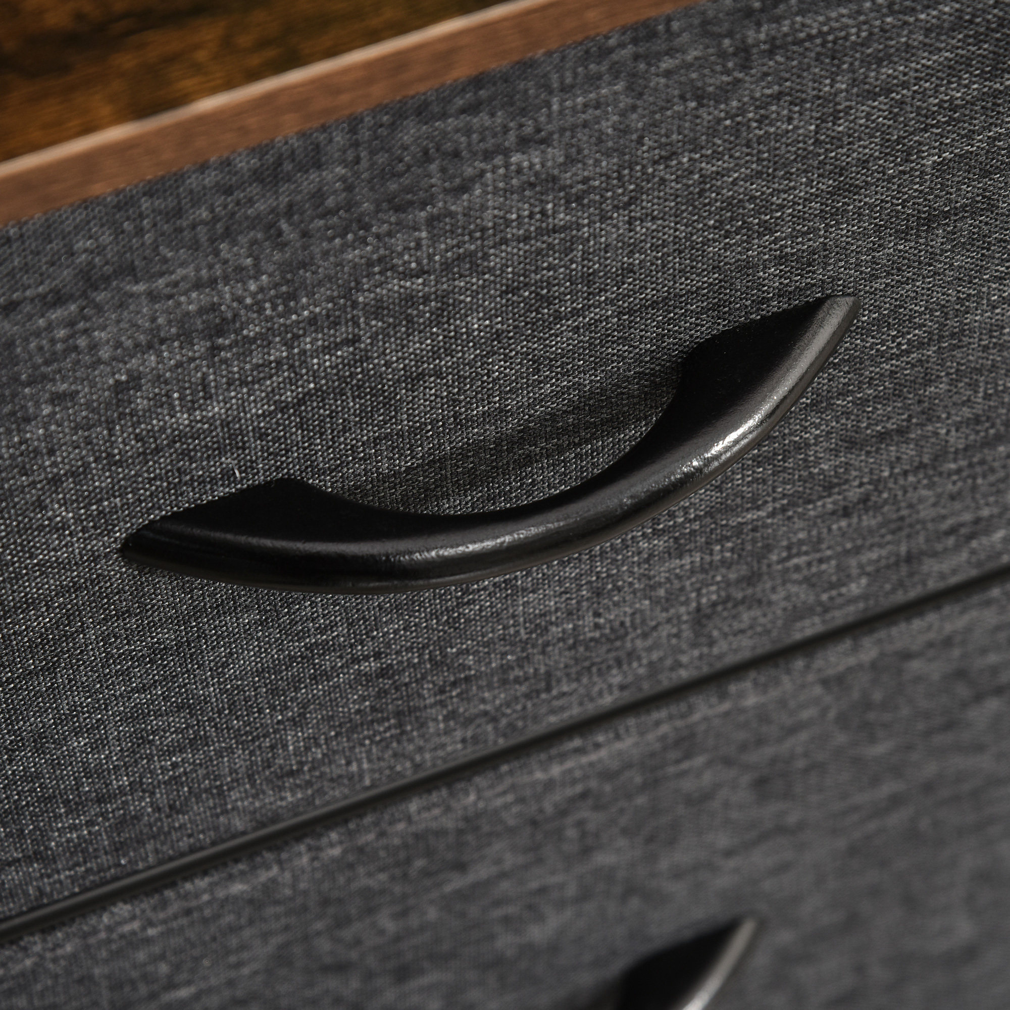 Tirador de cajón de tela gris oscuro con detalle de marco de madera.