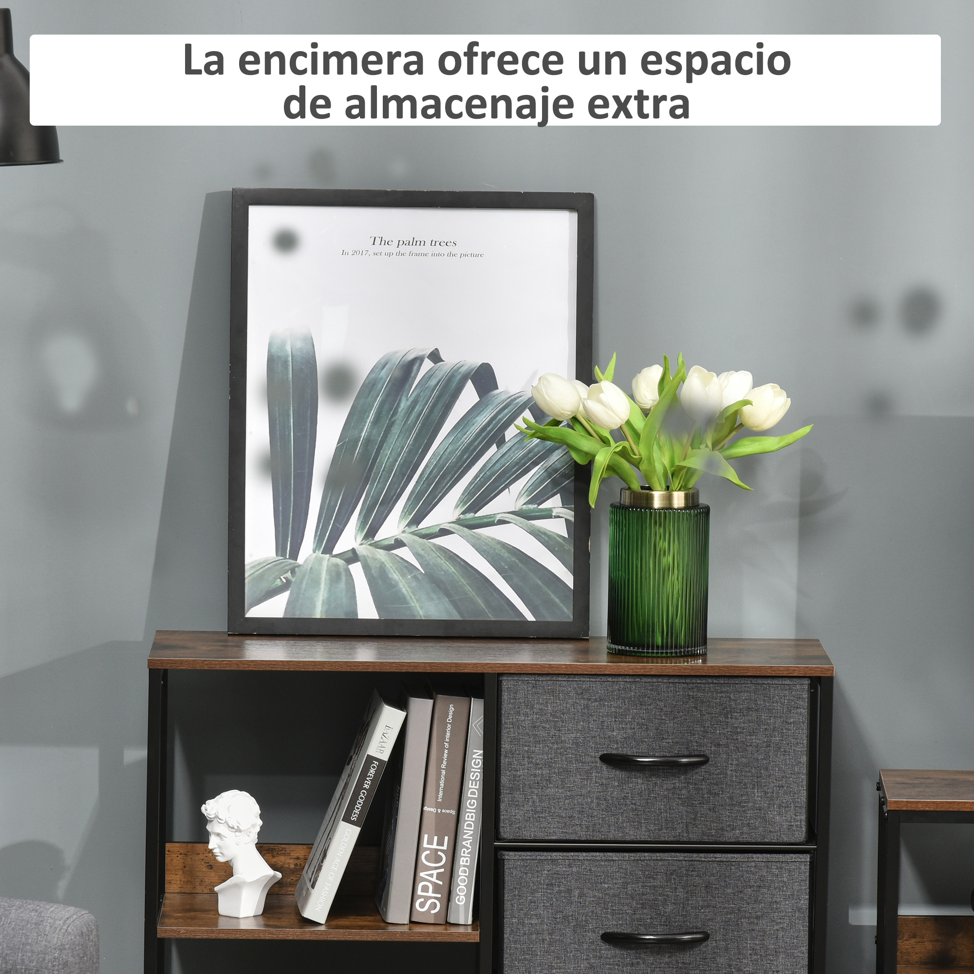 Una mesita de noche con dos cajones, un cuadro y flores.