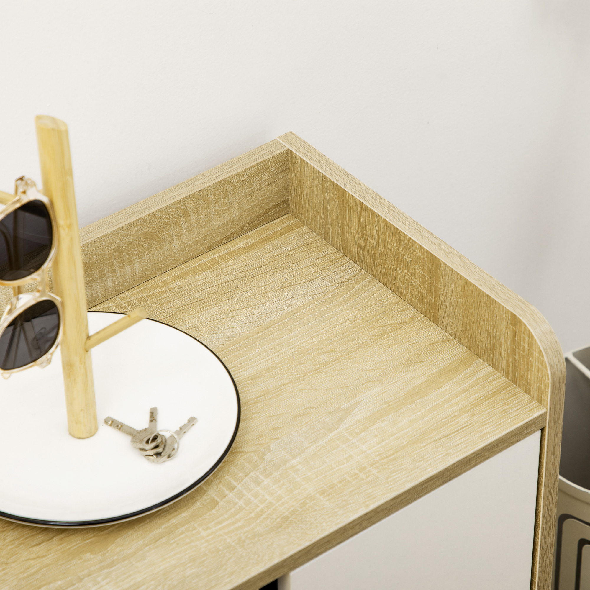 Gafas de sol en soporte de madera sobre plato blanco con llaves.
