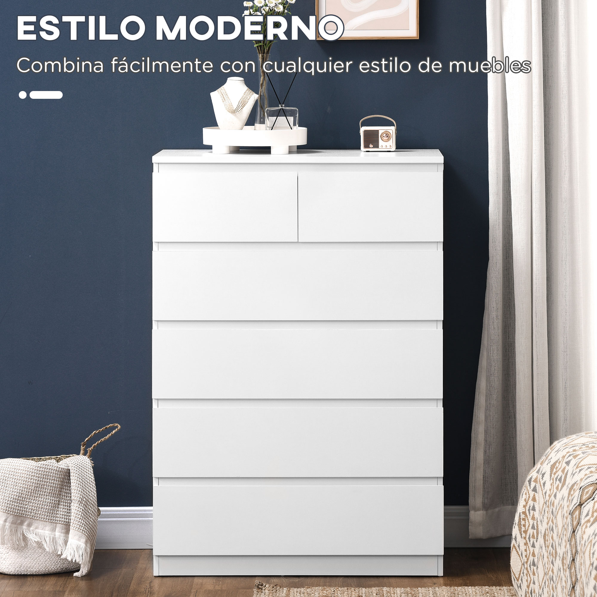 Una cómoda blanca delante de una pared azul oscuro. Decoración encima.