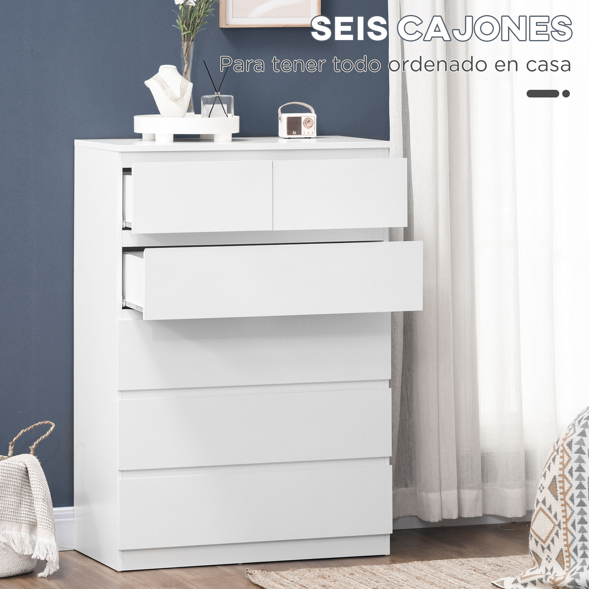 Cómoda blanca de seis cajones sobre suelo de madera.