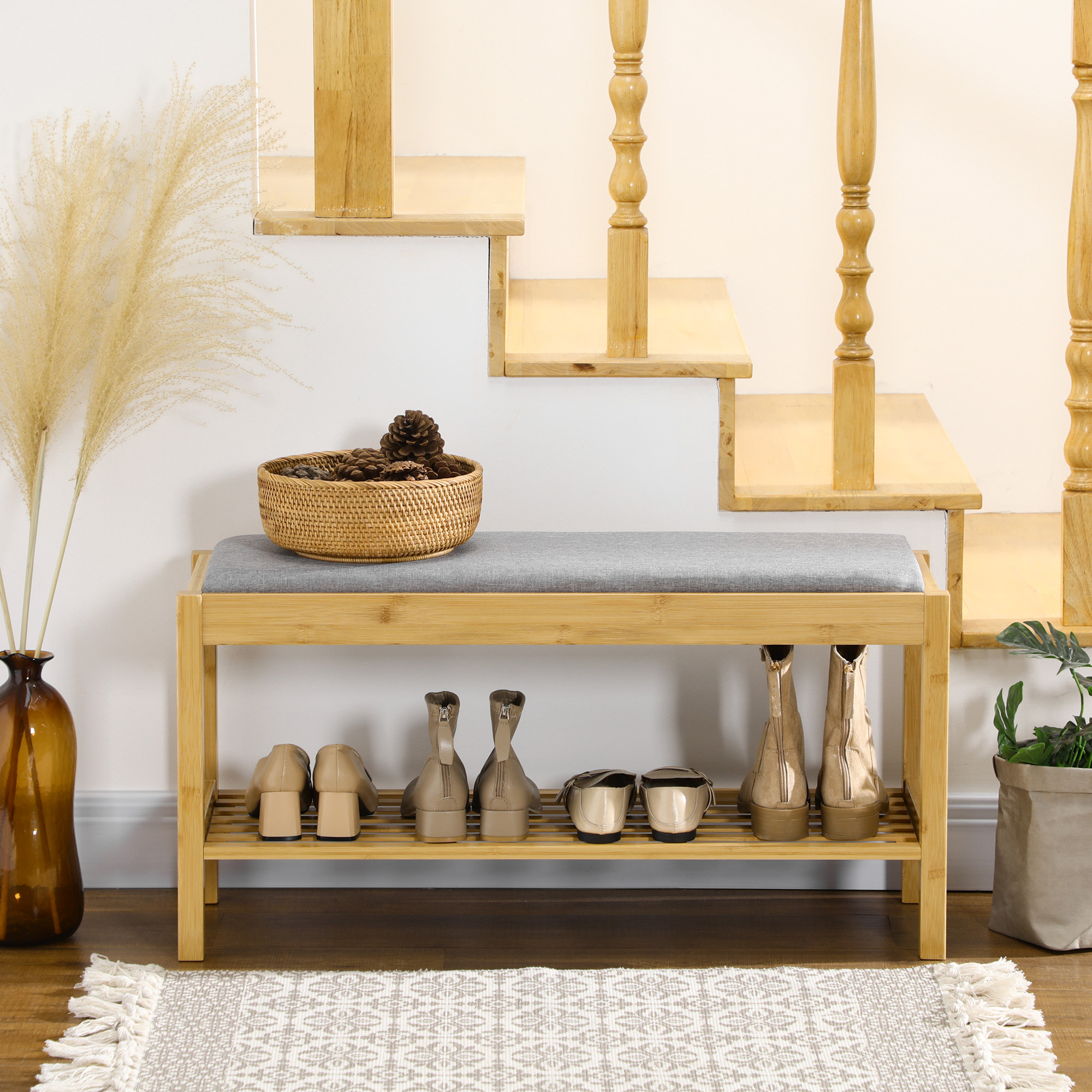 Zapatero de madera con banco, zapatos, cesta de piñas y planta.