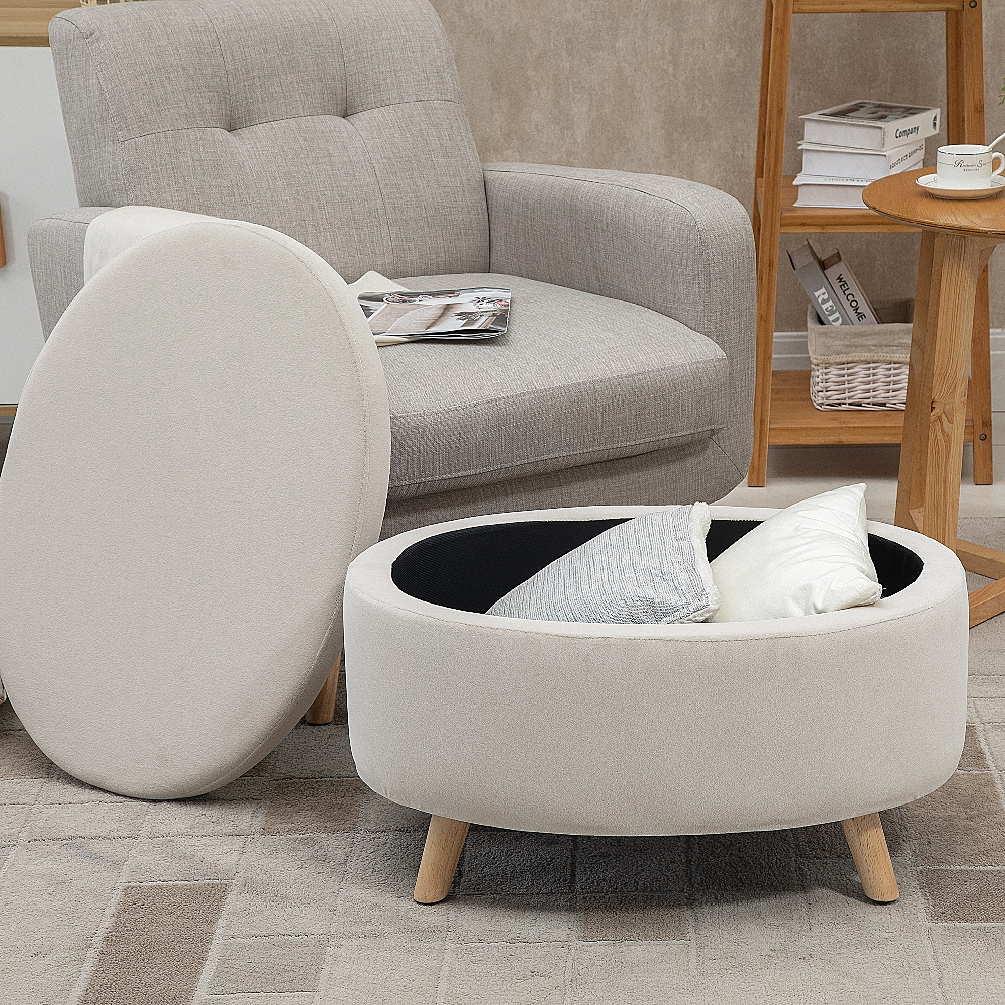 Un puf color crema con patas de madera y cojines junto a un sillón gris.