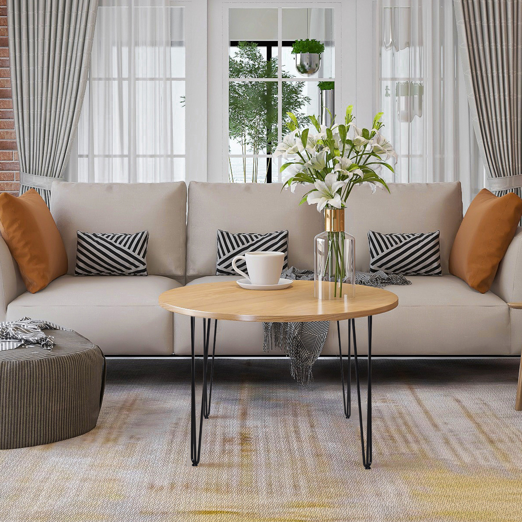 Un salón luminoso con sofá beige, mesa de centro de madera y lirios blancos.