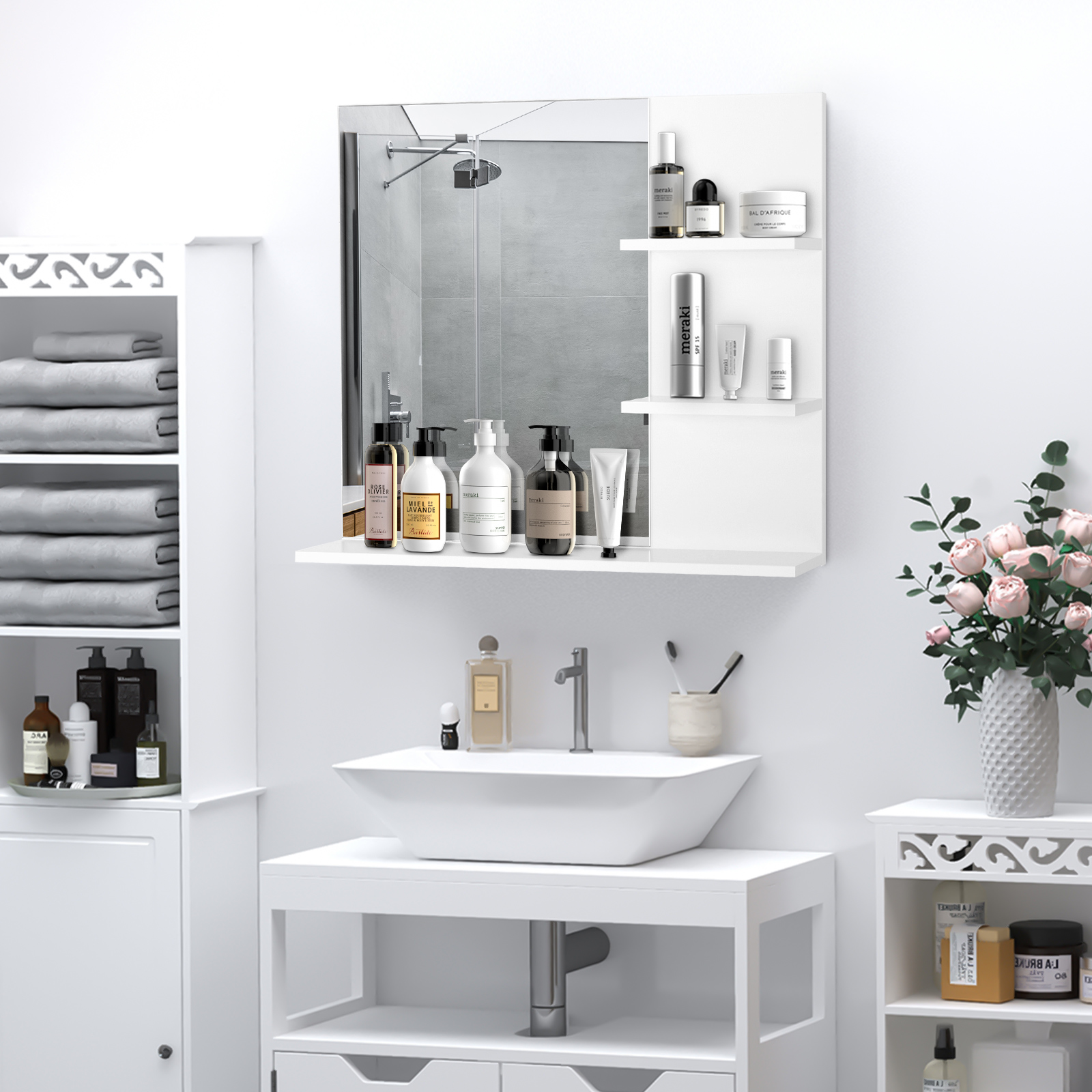 Un baño con lavabo, espejo, armarios y flores.