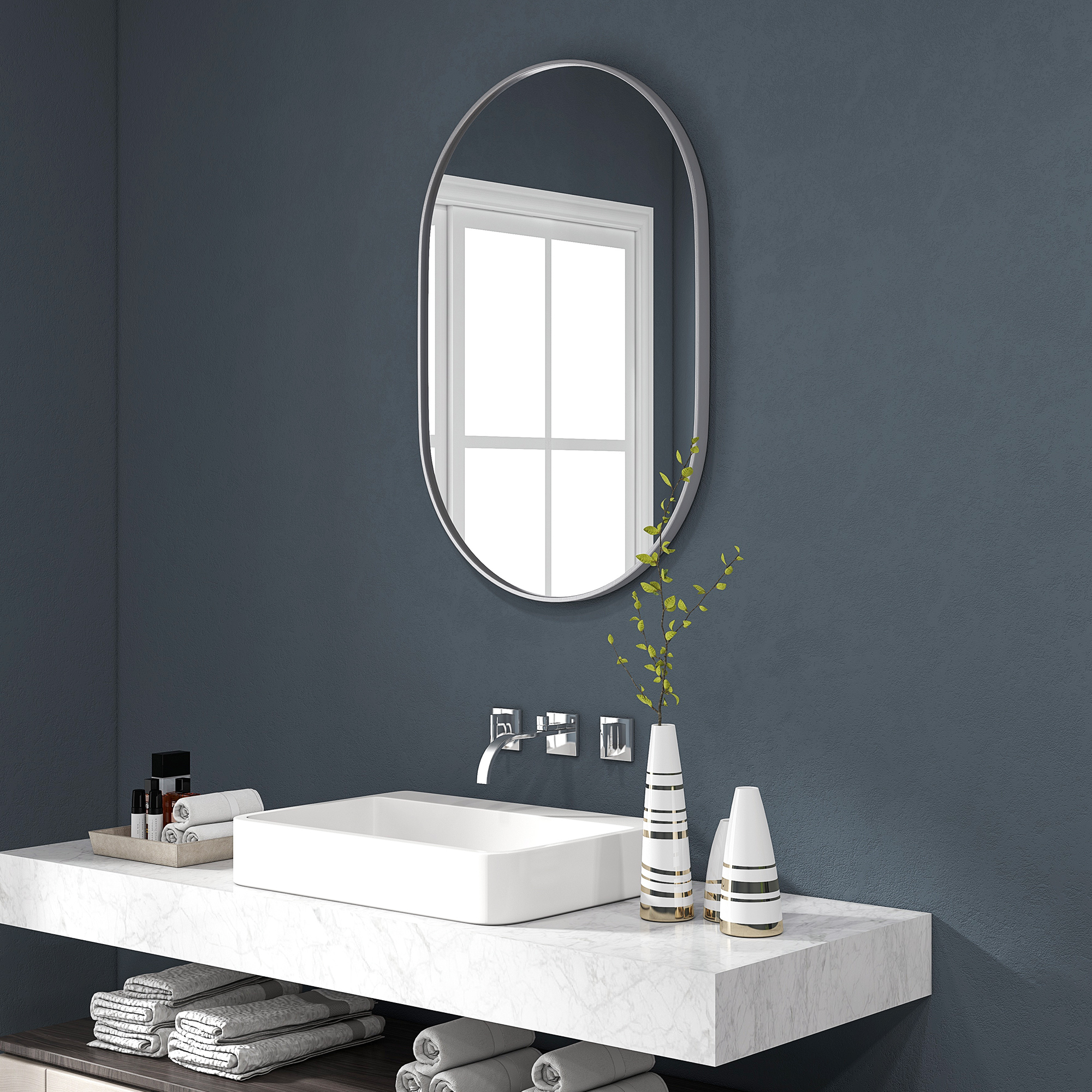 Un baño moderno con lavabo, espejo y jarrones decorativos sobre encimera de mármol.