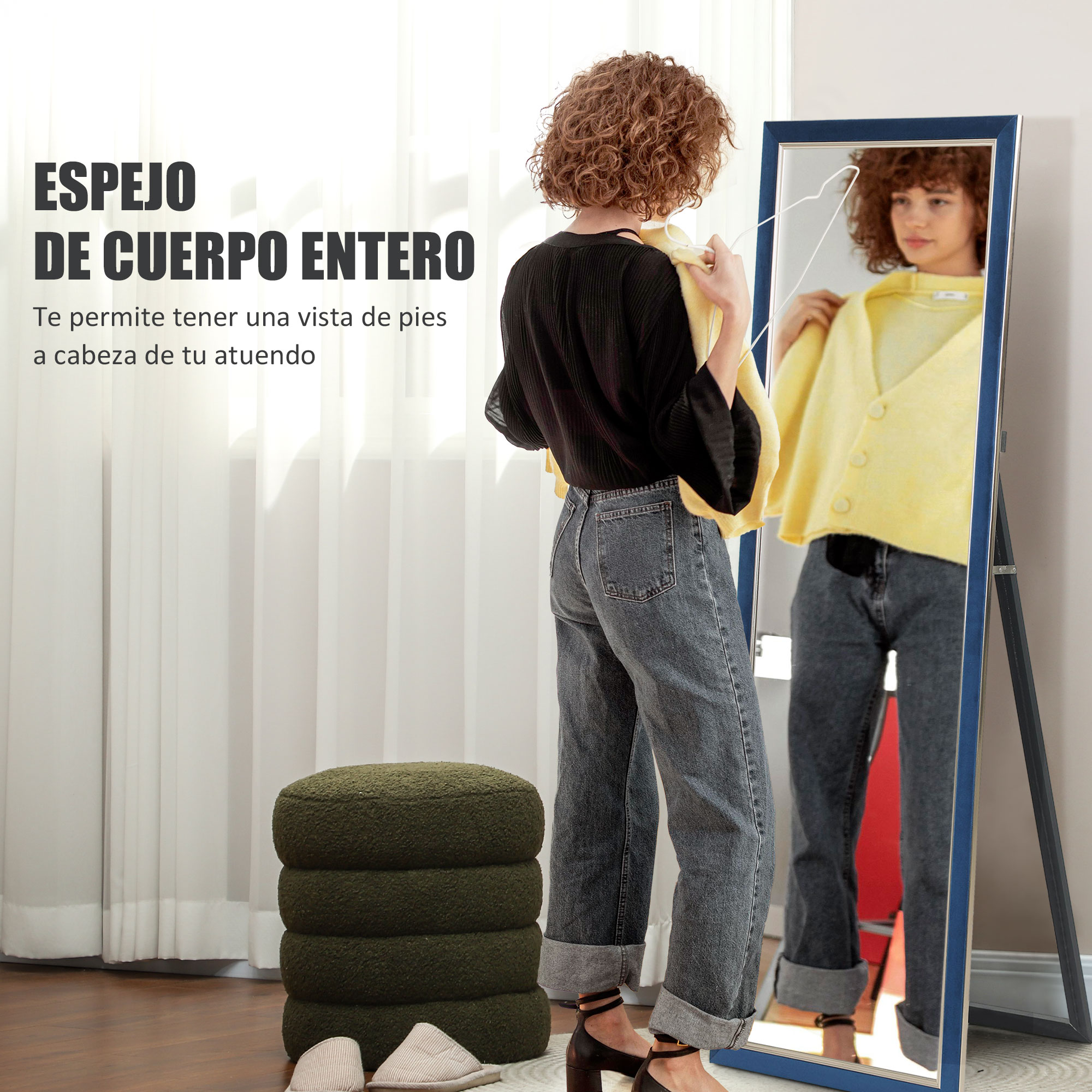 Una mujer se para frente a un espejo de cuerpo entero sosteniendo una prenda amarilla.