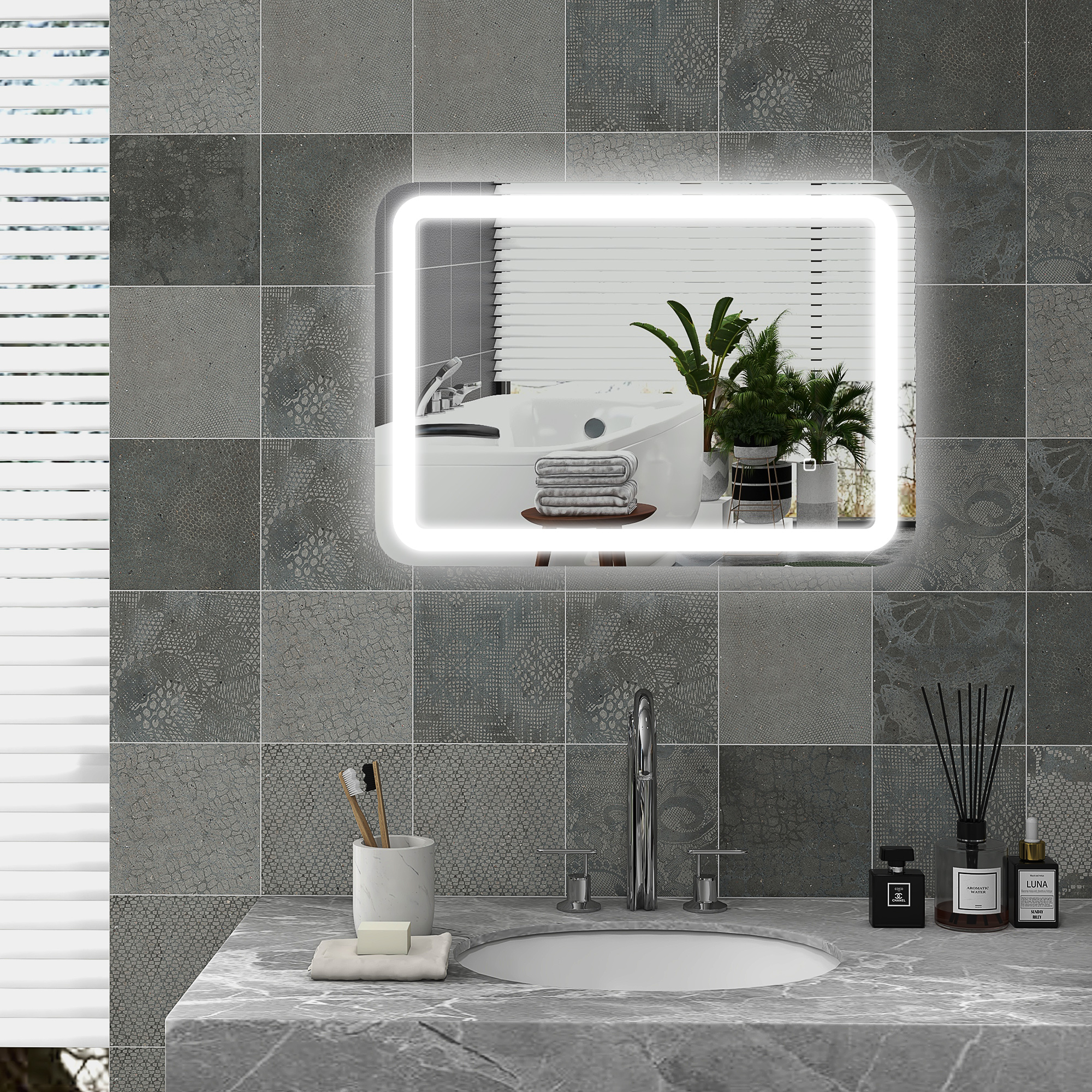 Tocador de baño moderno con lavabo, grifo, artículos de tocador y plantas reflejados en un espejo iluminado.