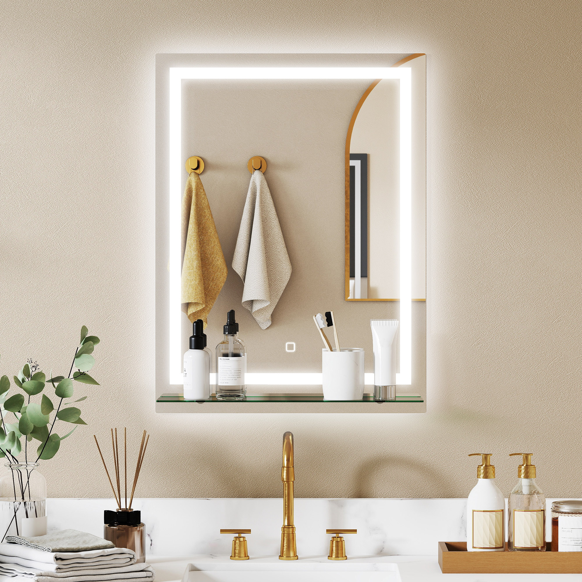 Un espejo iluminado sobre un lavabo con grifería dorada, toallas y artículos de tocador.