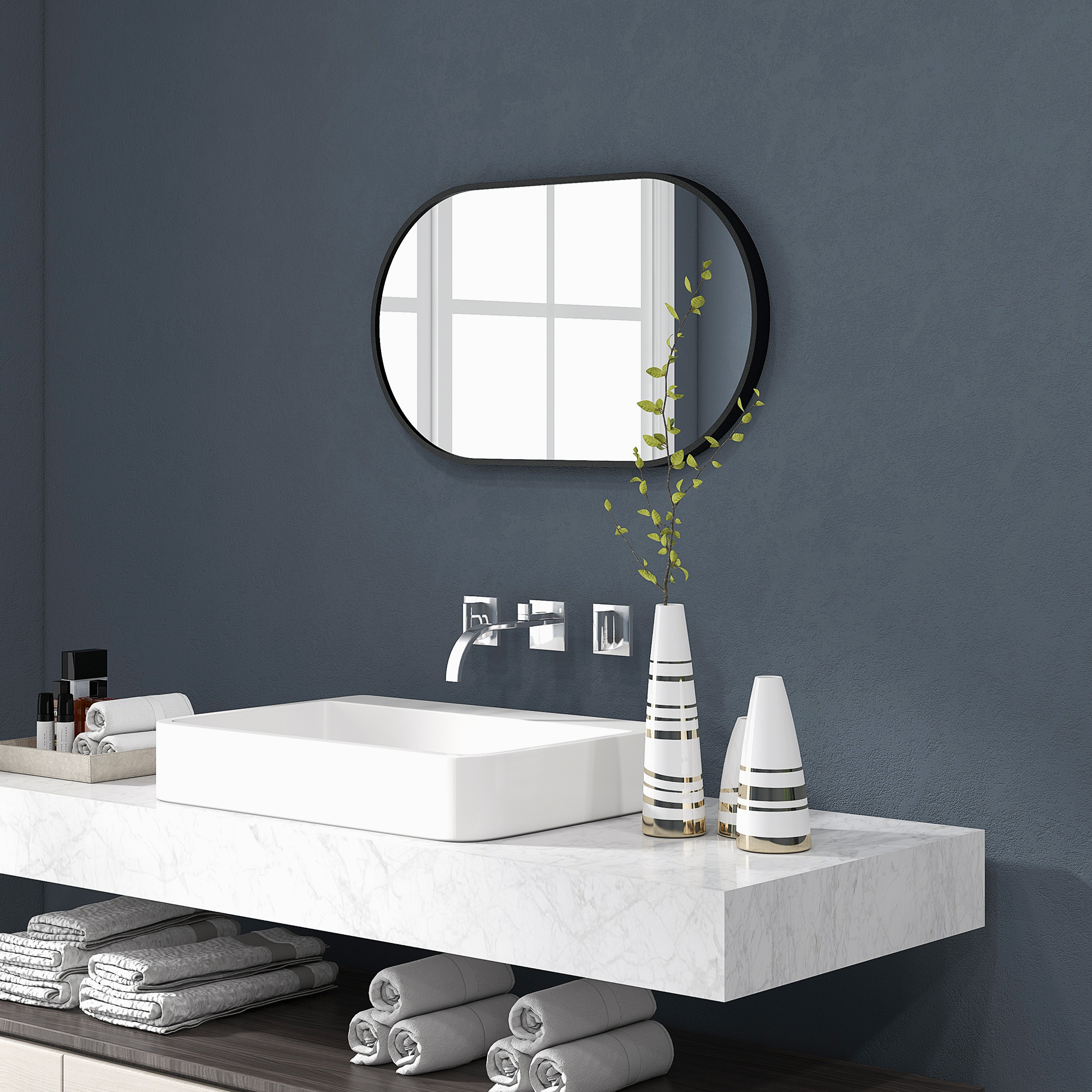 Un baño con lavabo blanco, espejo y toallas.