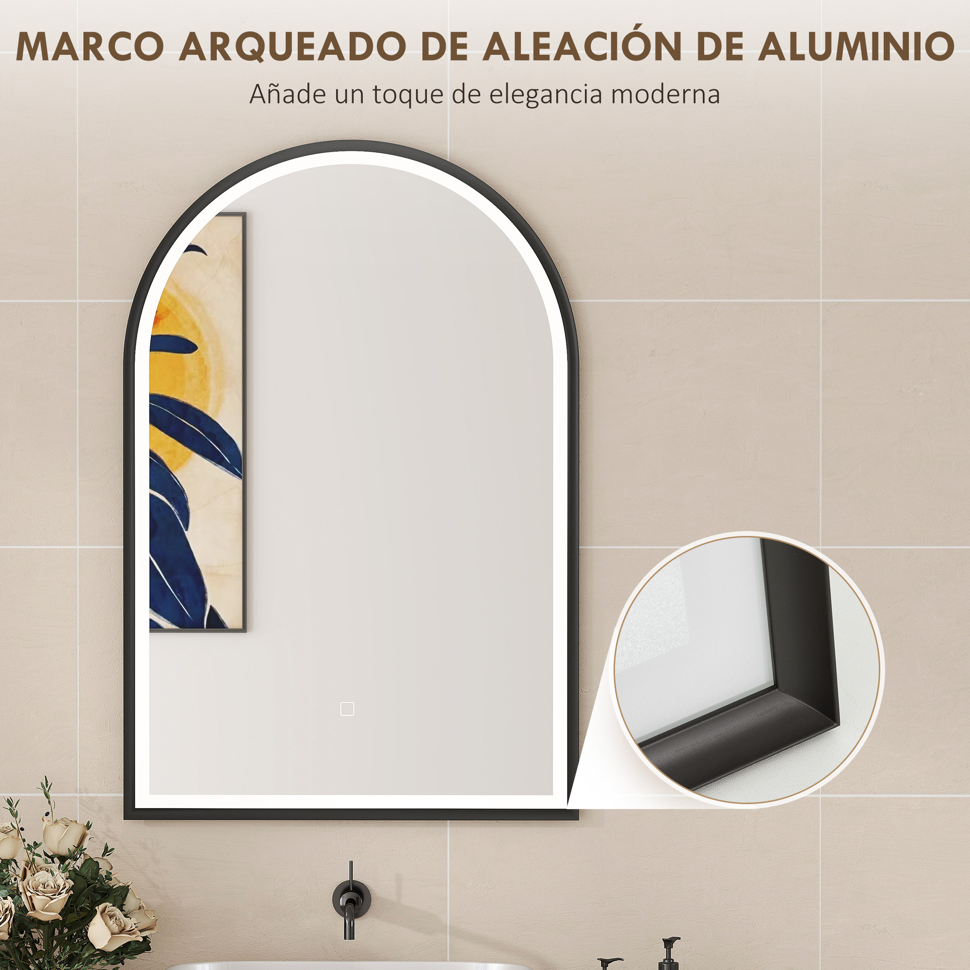 Un espejo moderno e iluminado con marco negro sobre un lavabo con flores.