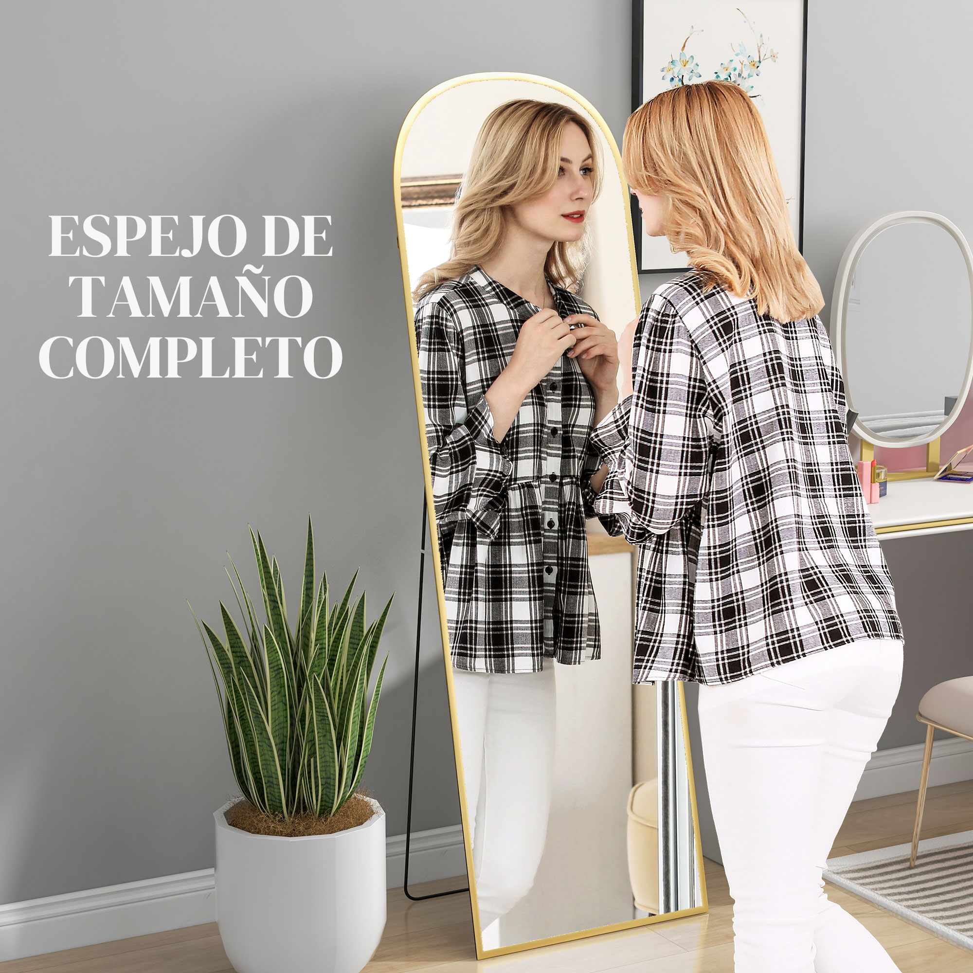 Una mujer con camisa a cuadros y pantalones blancos se para frente a un espejo de cuerpo entero.