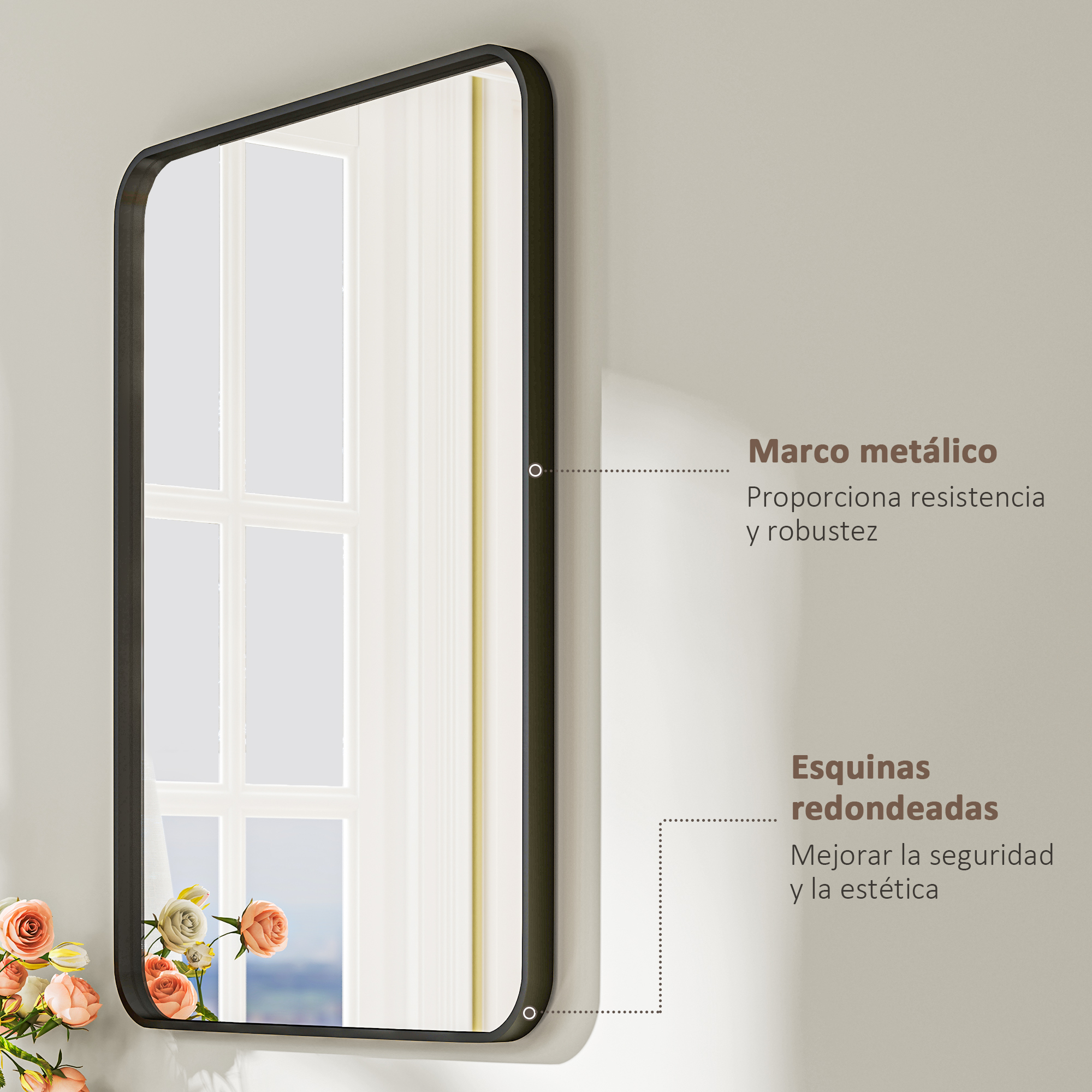 Un espejo con marco metálico negro y esquinas redondeadas, con flores delante.