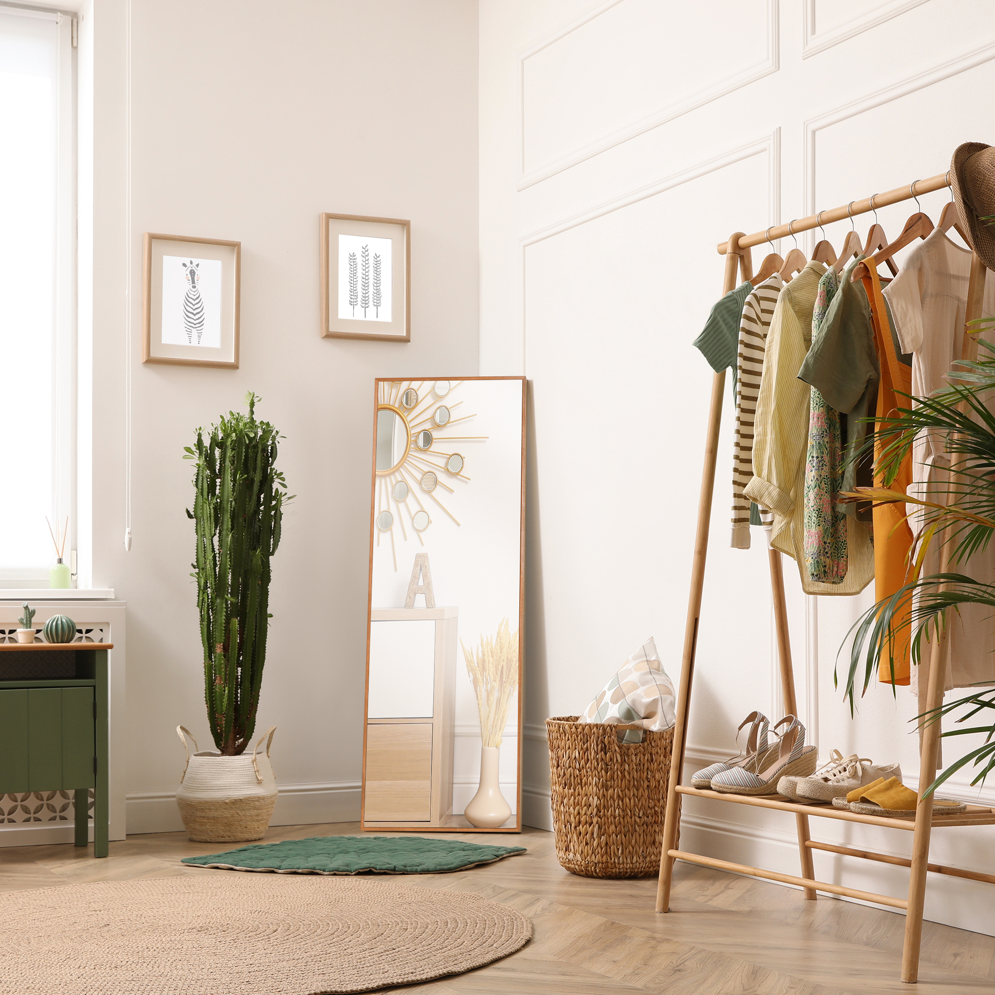 Un perchero con ropa, espejo, plantas y decoración en una habitación.