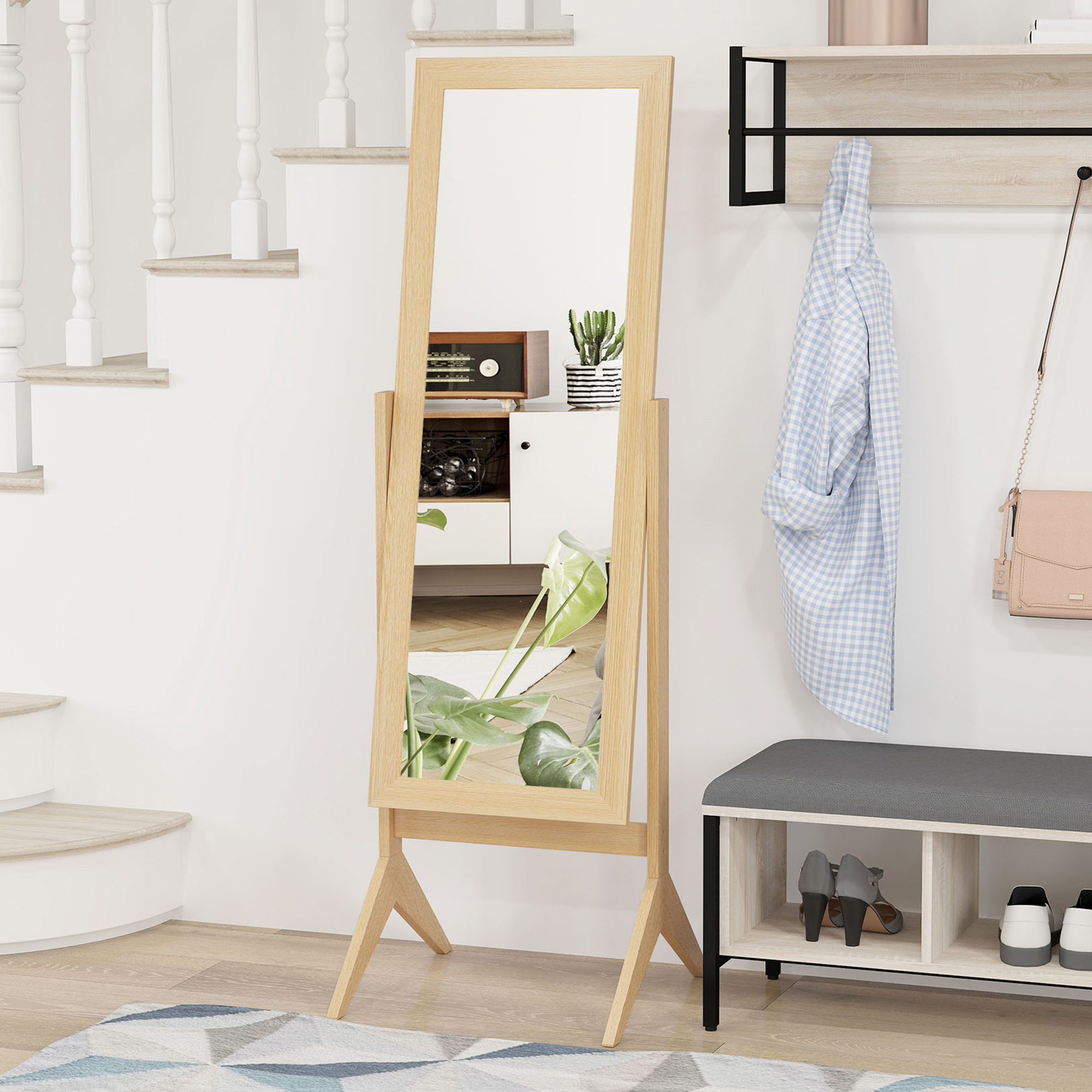 Un espejo de cuerpo entero junto a unas escaleras, con zapatero y ropa.