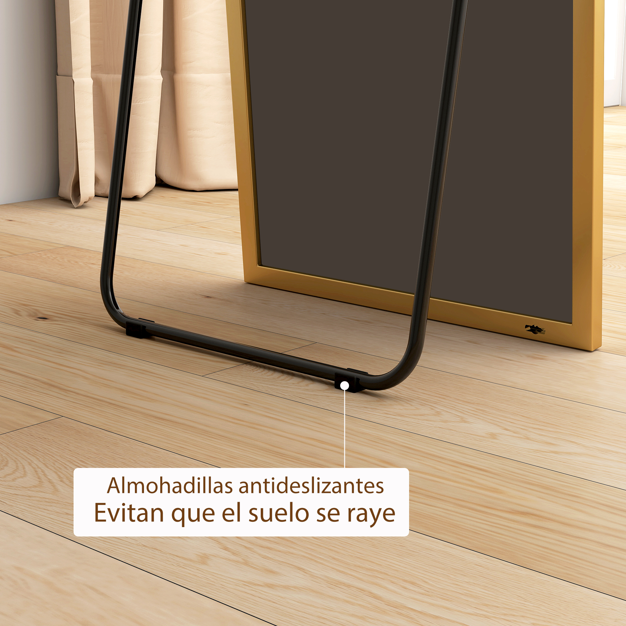 Un espejo dorado con marco negro y soporte negro sobre suelo de madera.