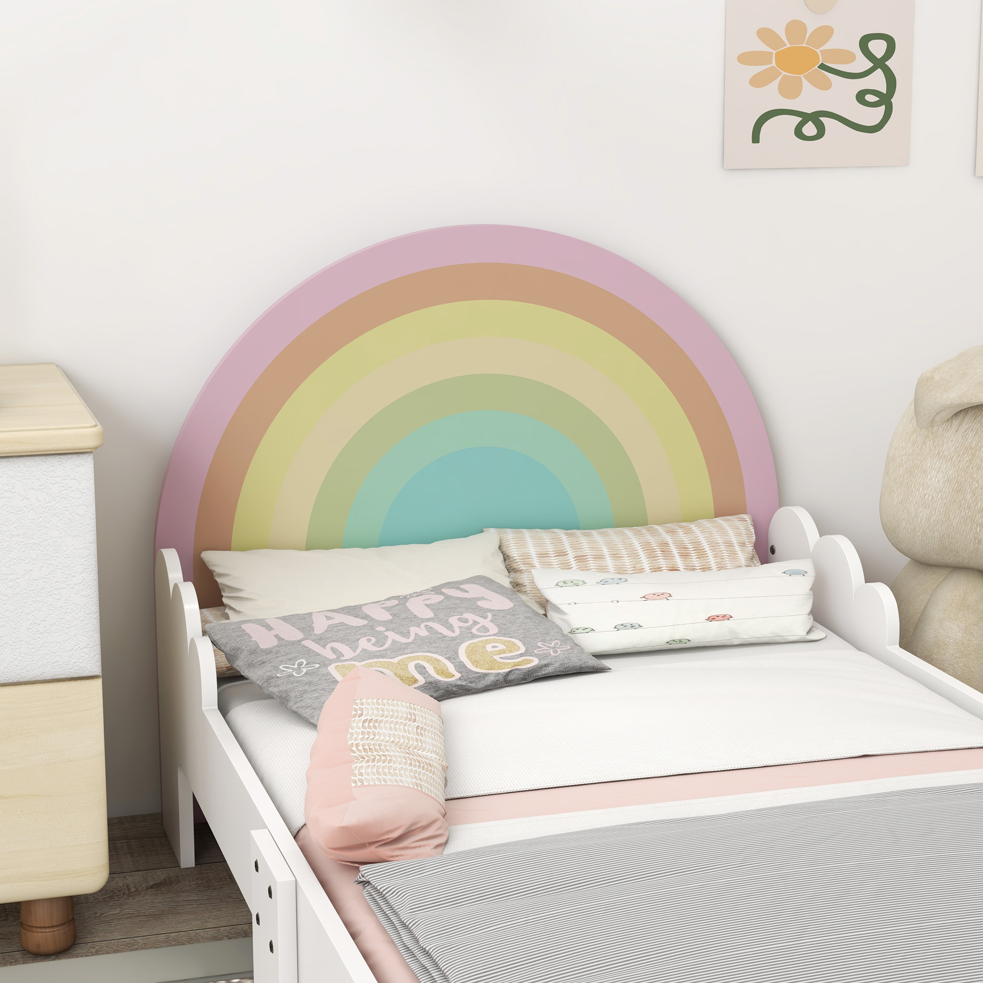 Cama infantil con cabecero de arcoíris, cojines y ropa de cama a rayas.