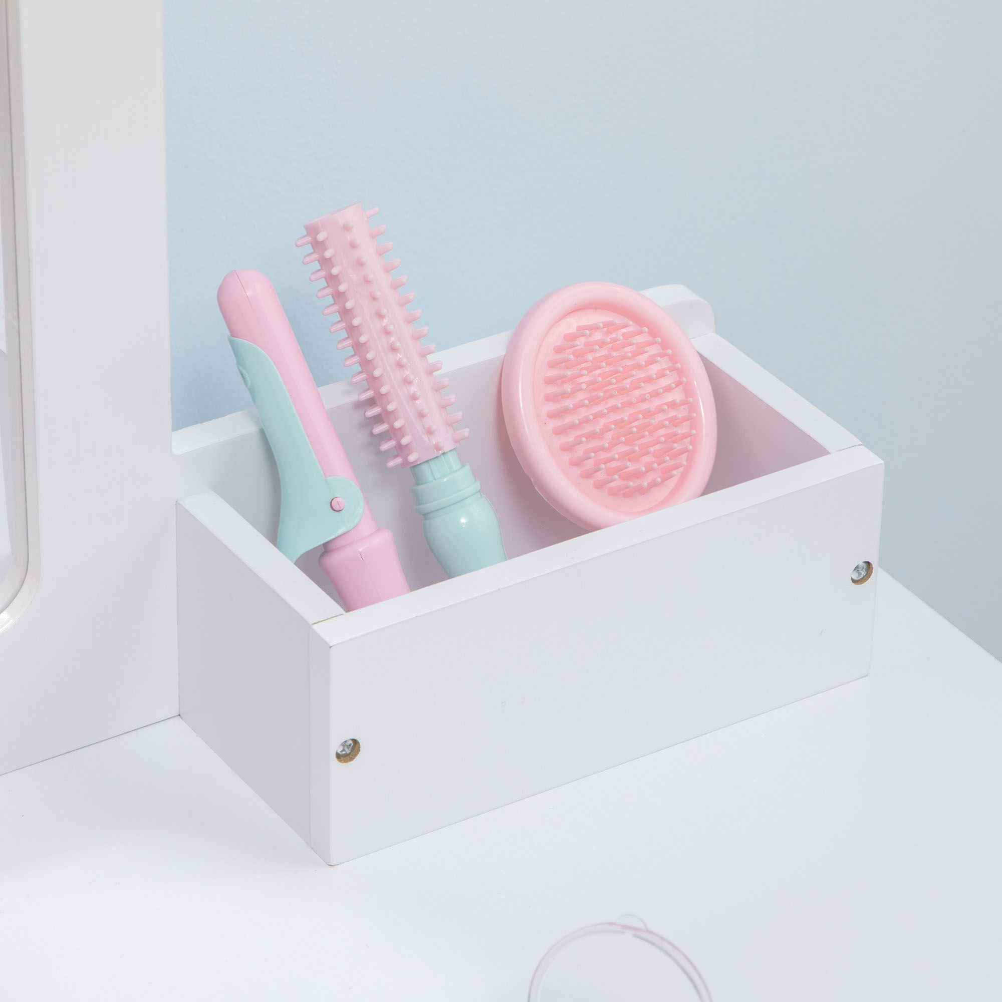 Un contenedor blanco con accesorios para el cabello rosa y verde menta.