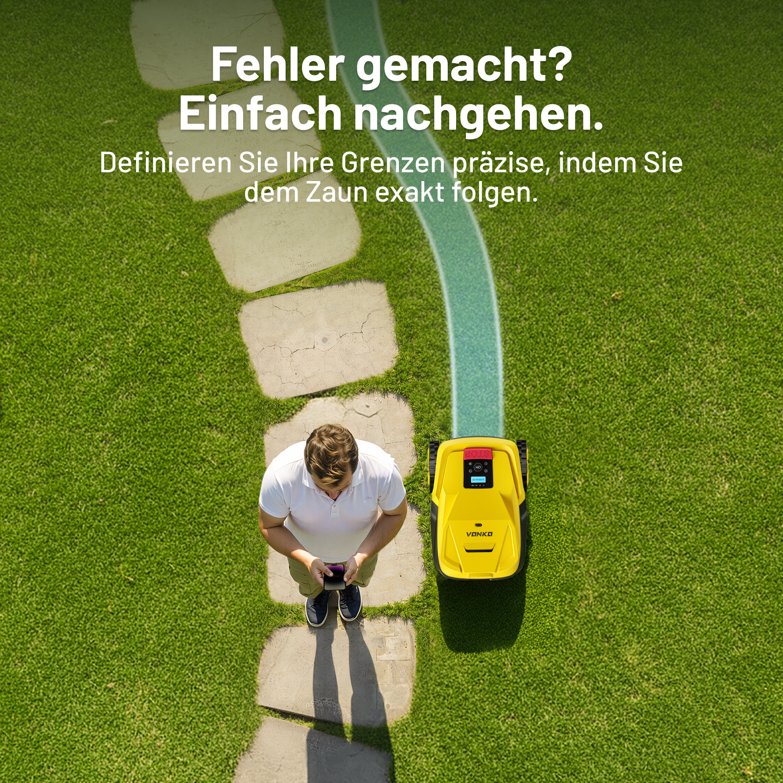 Ein Mann mit Handy steht auf einem Weg neben einem Mähroboter.