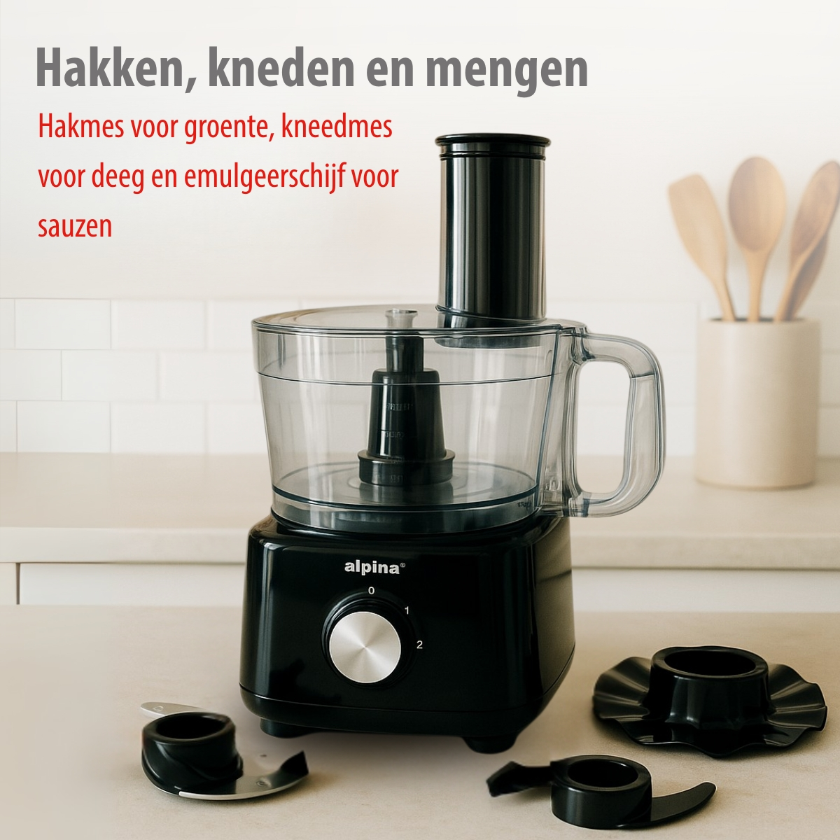 Black food processor with clear bowl and three attachments on a countertop.