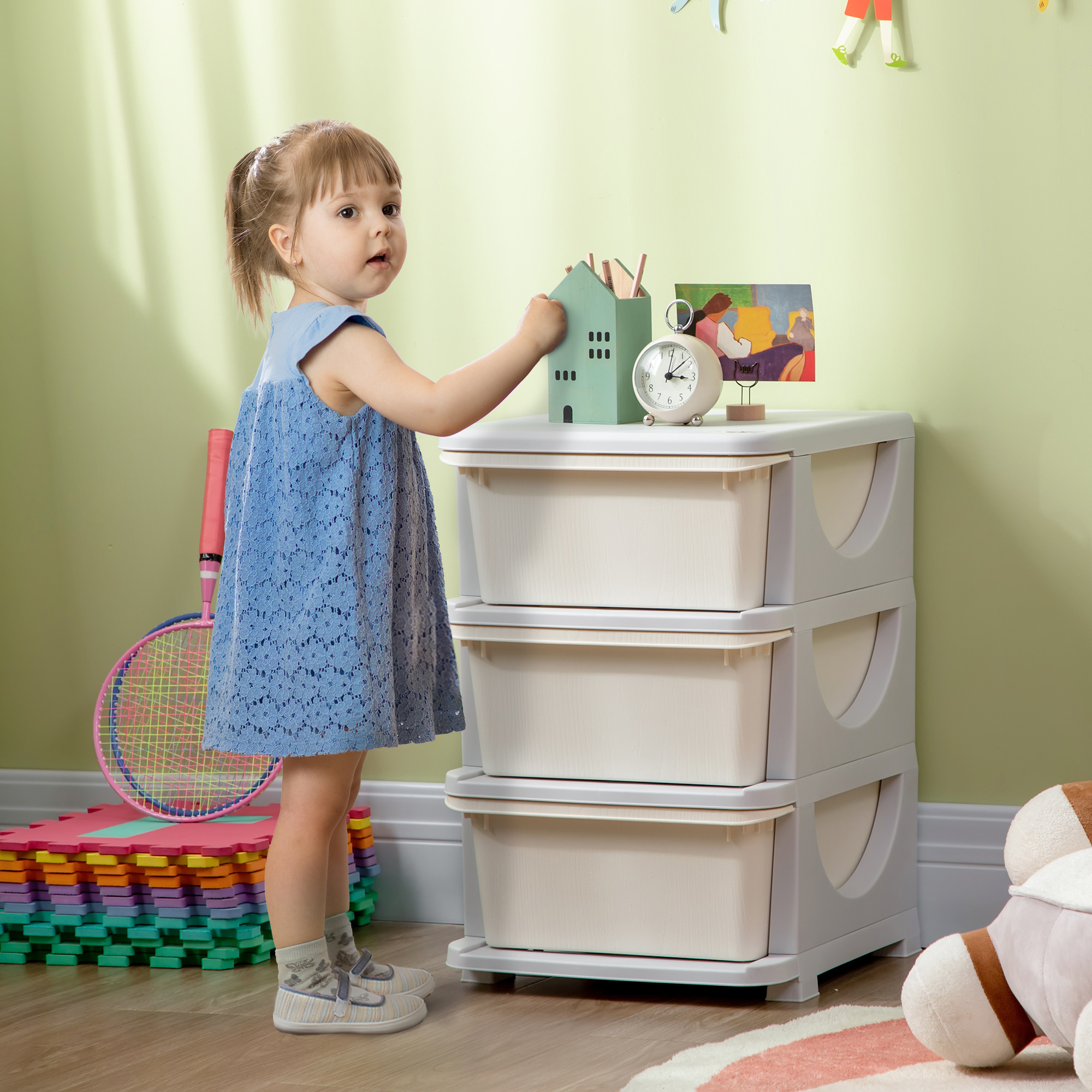 Una niña con vestido azul está junto a una torre de almacenamiento.
