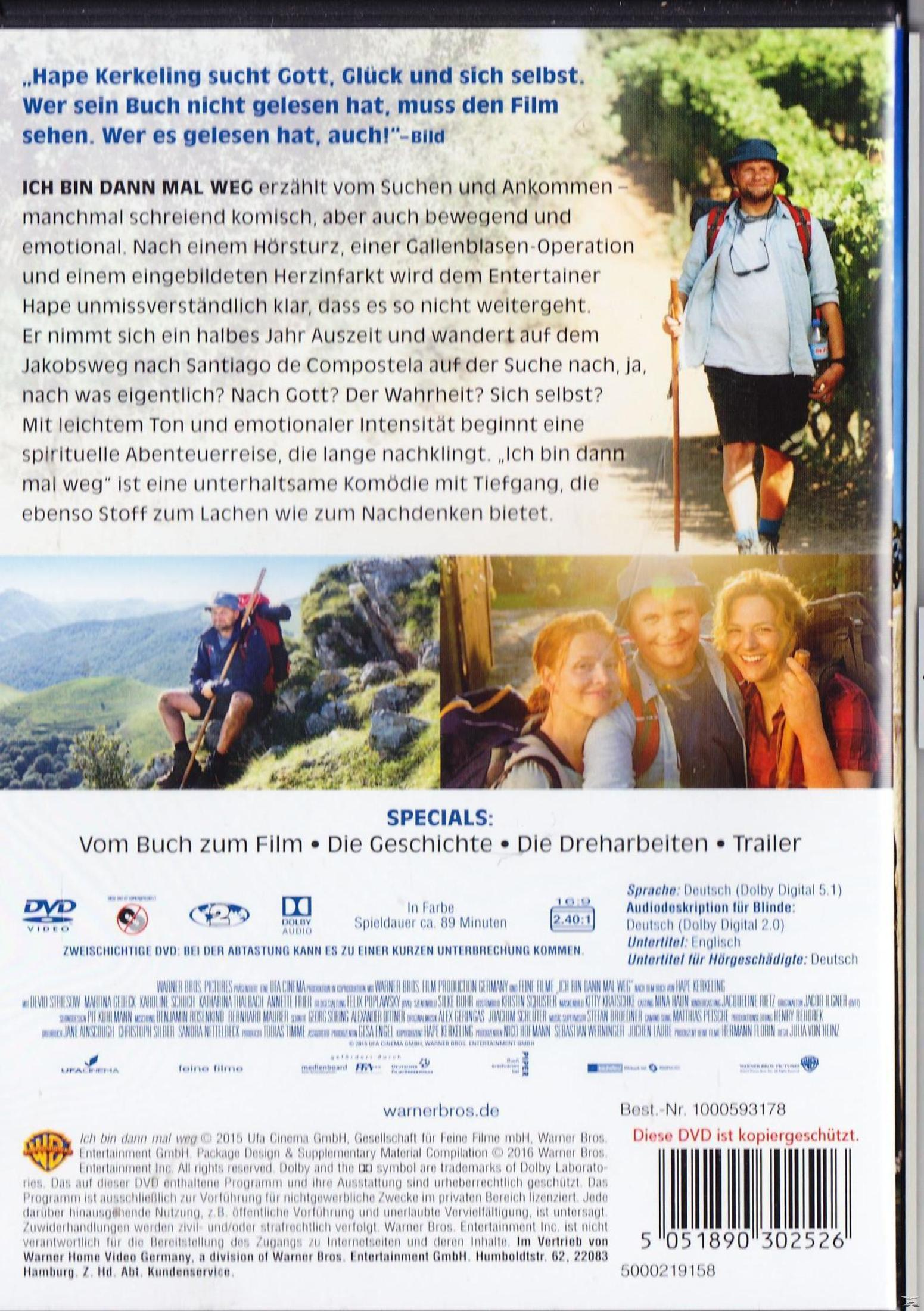 Ein Mann mit Rucksack und Hut wandert auf einem Feldweg, mit Bäumen im Hintergrund.