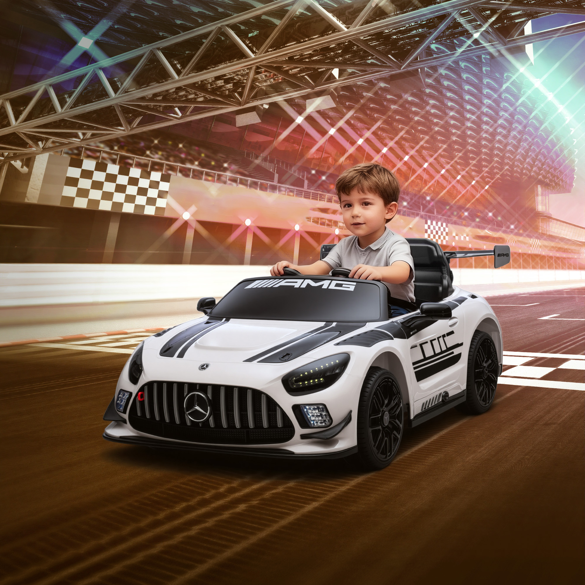 Un niño pequeño conduce un coche de juguete blanco en una pista de carreras con gradas al fondo.