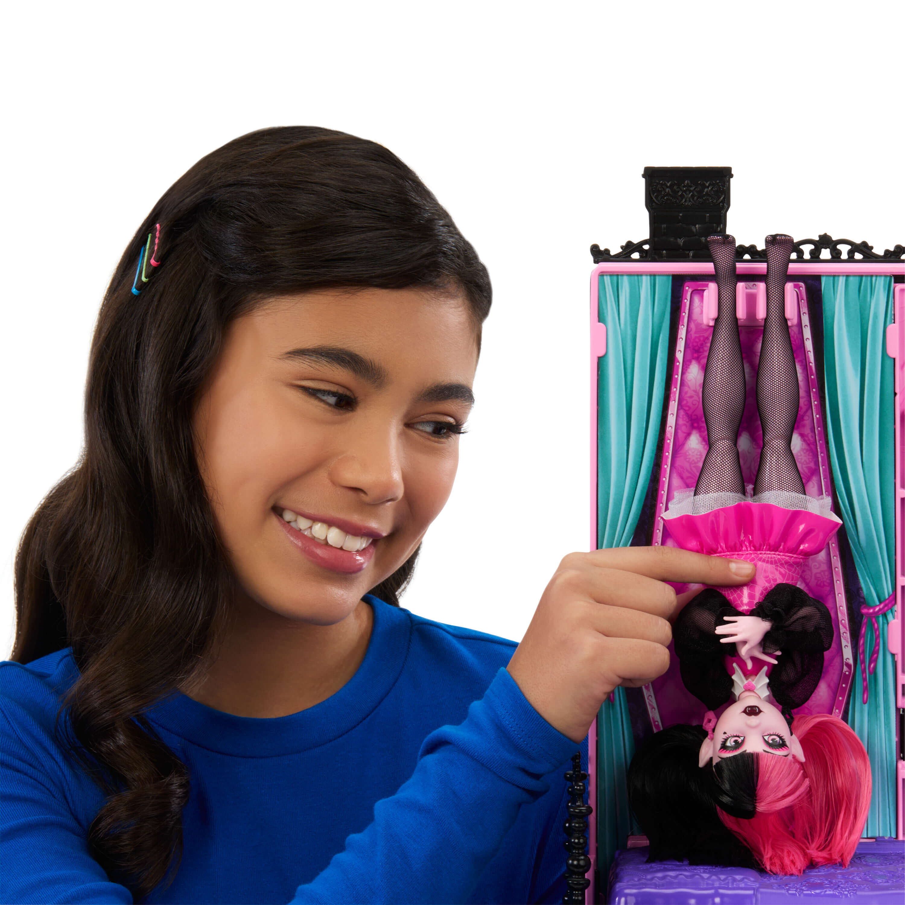 Mädchen mit Puppe, die kopfüber in einer rosa Bühne hängt.