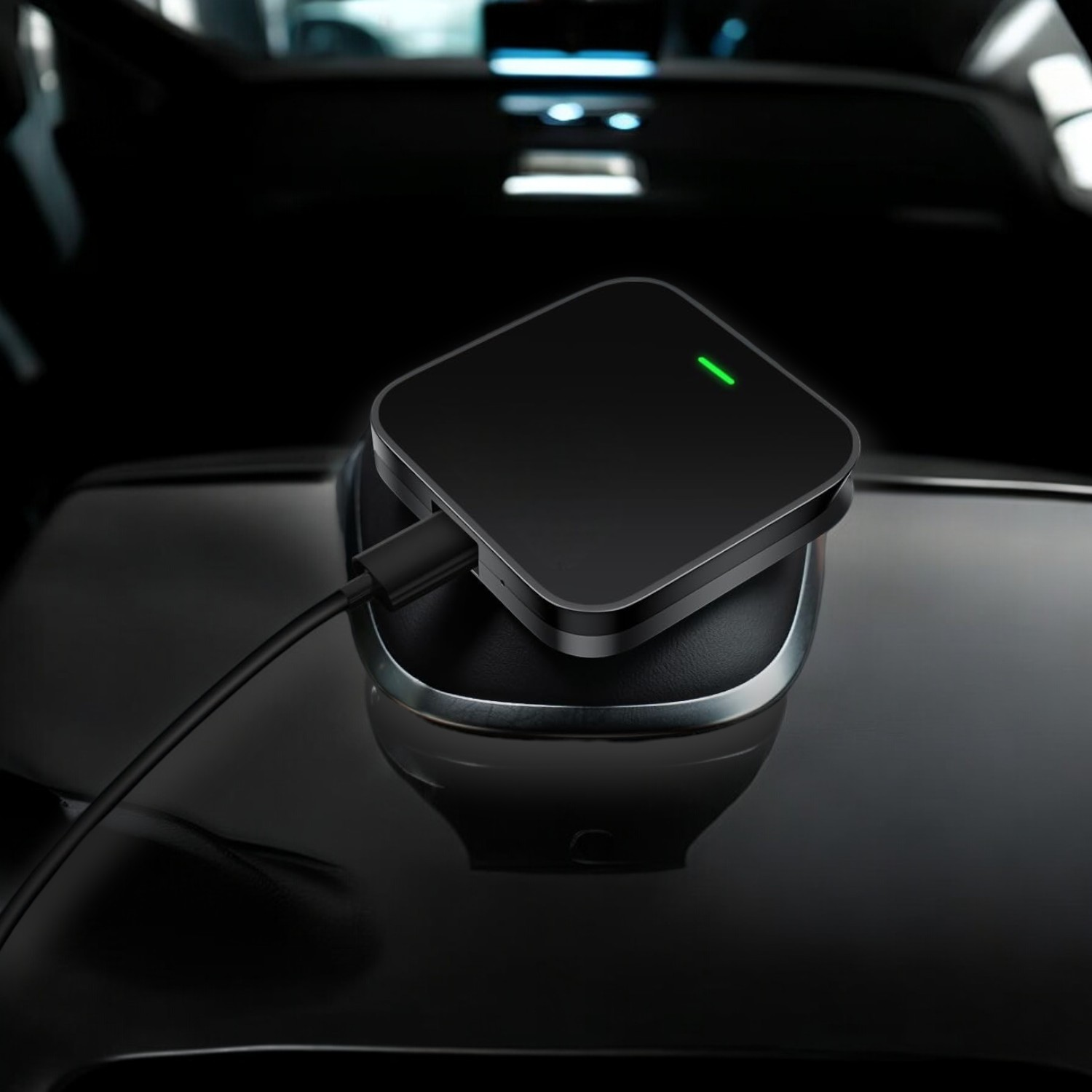 Cargador cuadrado negro con luz verde en una superficie oscura de coche.