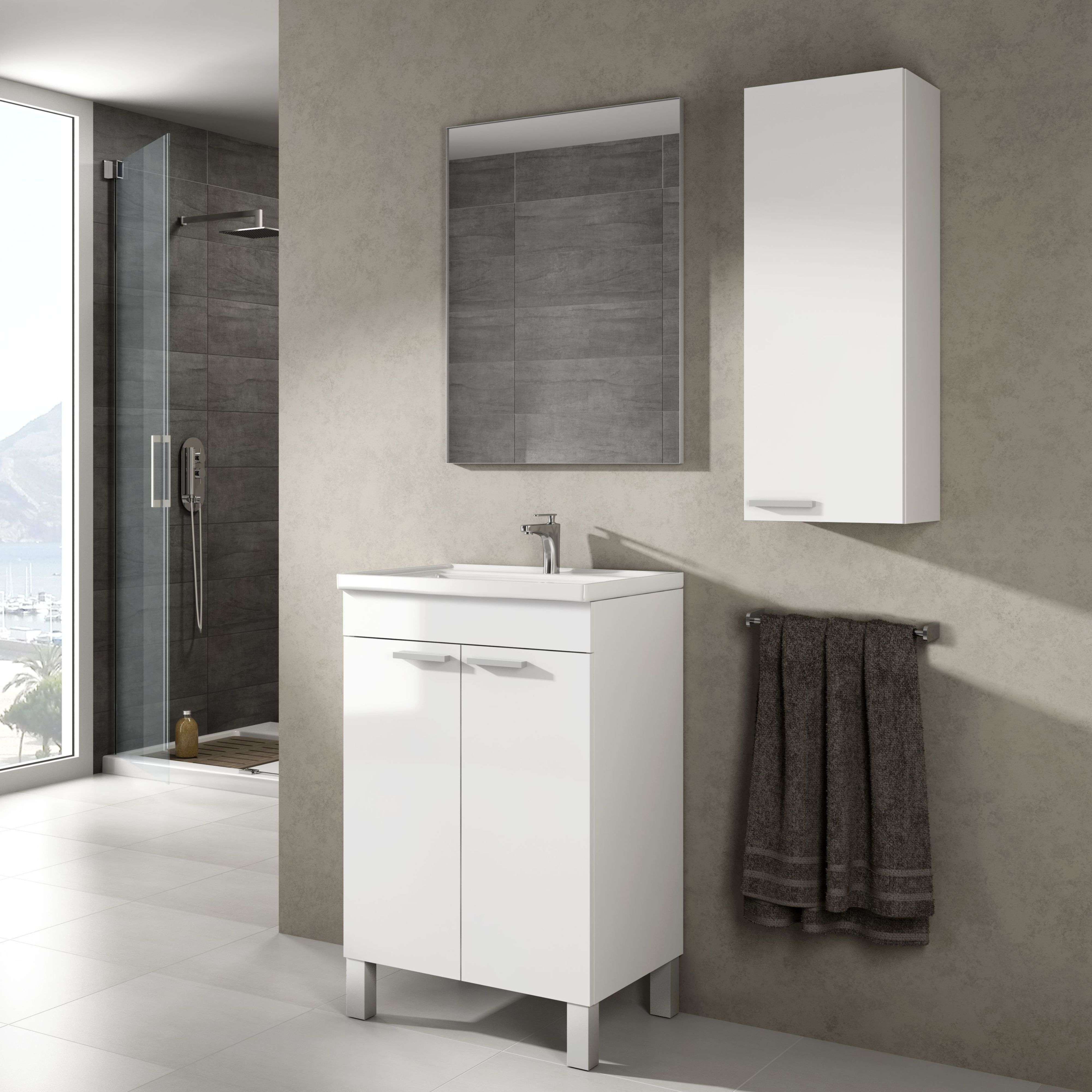 Baño moderno con mueble de lavabo blanco, espejo, cabina de ducha y toalla.