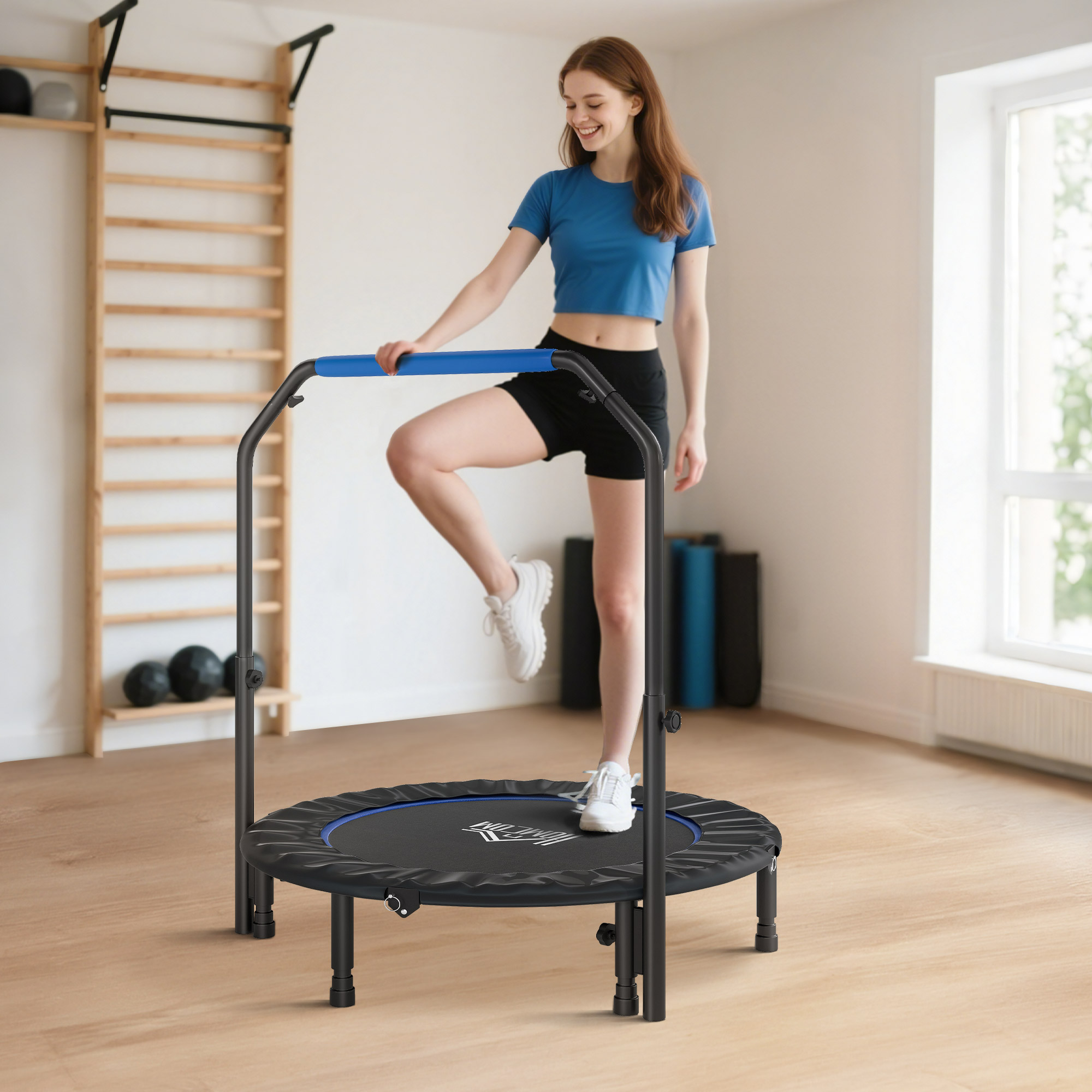 Mujer en un trampolín con barra de agarre, junto a una barra de pared de madera y esterillas.