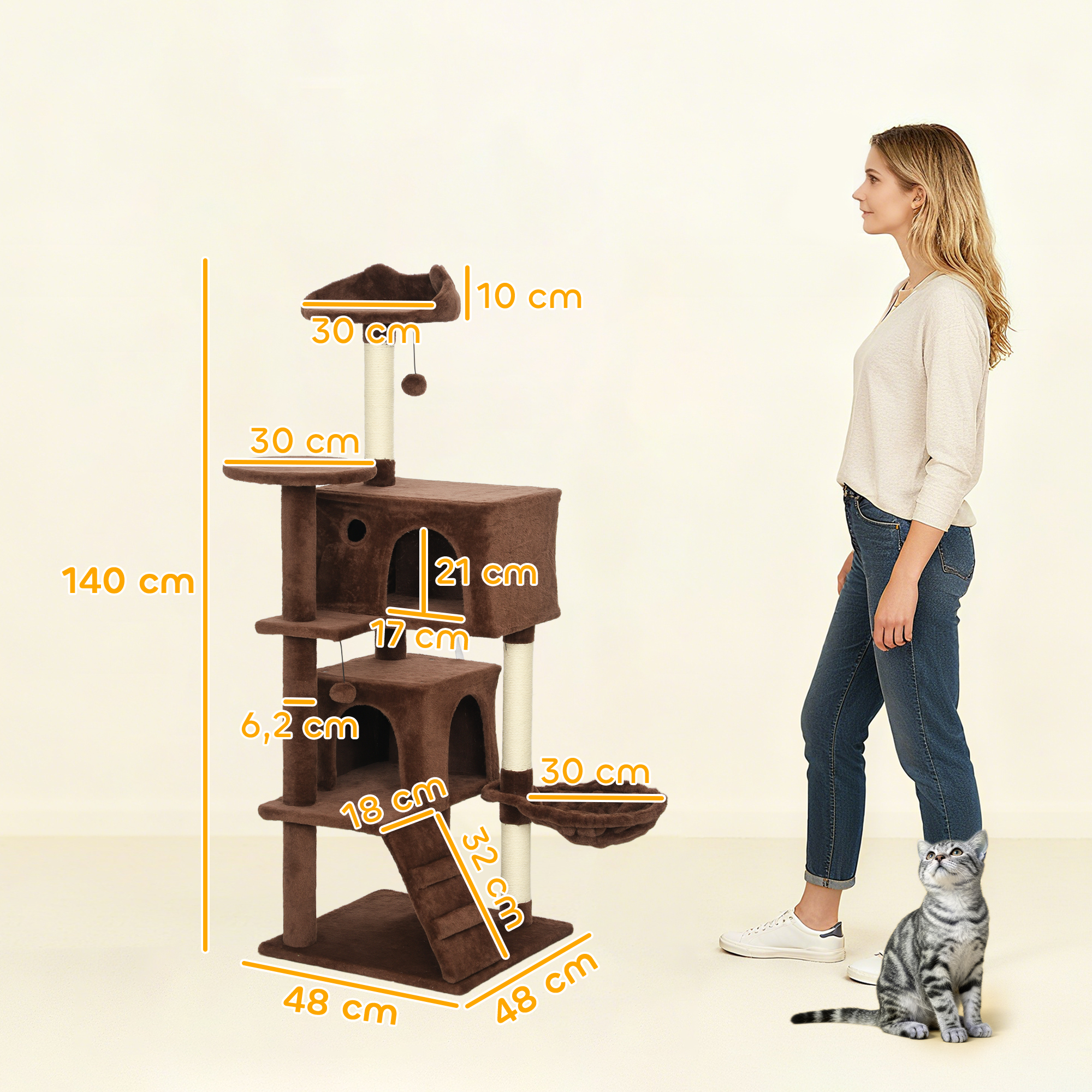 Árbol rascador marrón con hamaca, plataformas y juguetes. Mujer al lado.