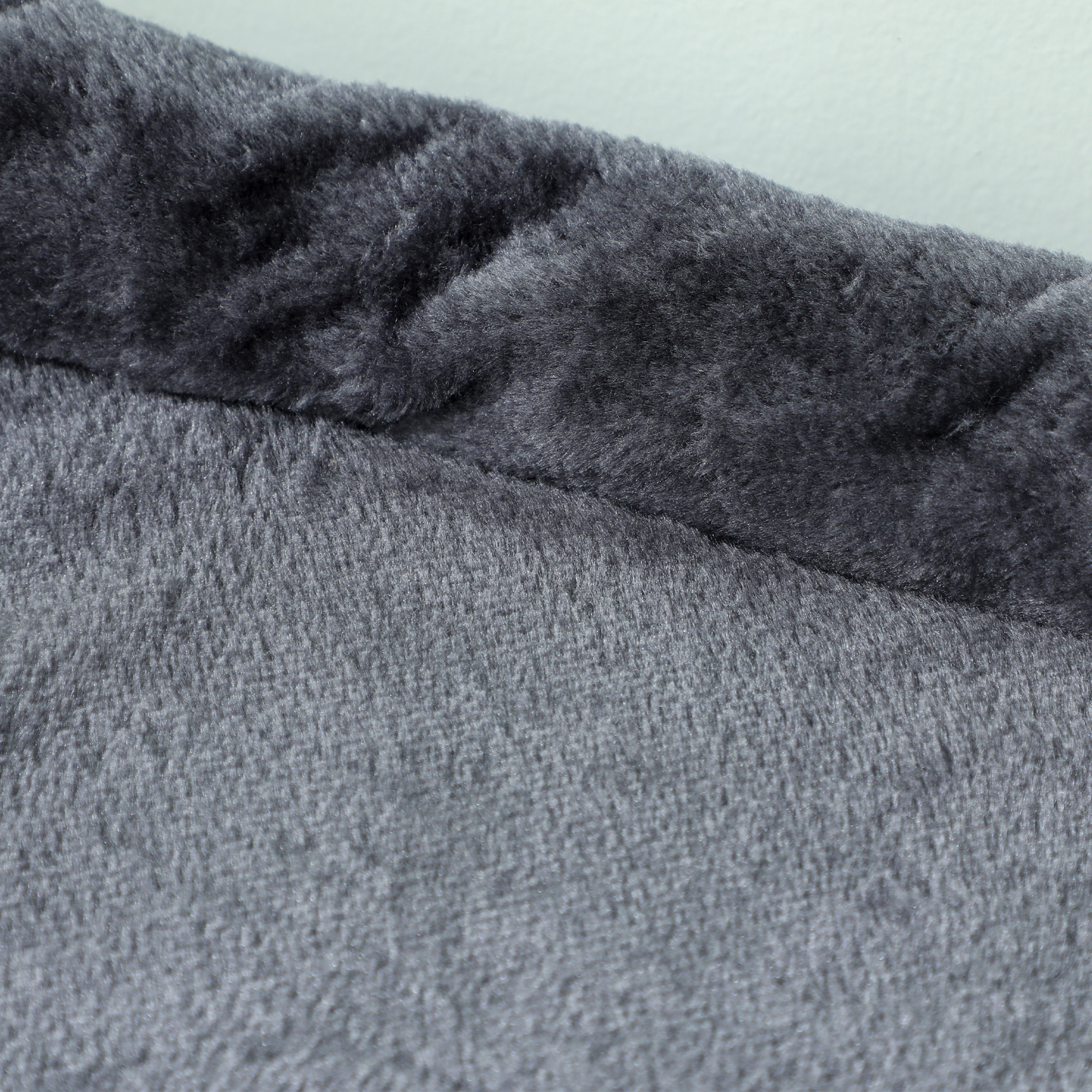 Primer plano de tela gris oscuro y esponjosa con una ligera curva.