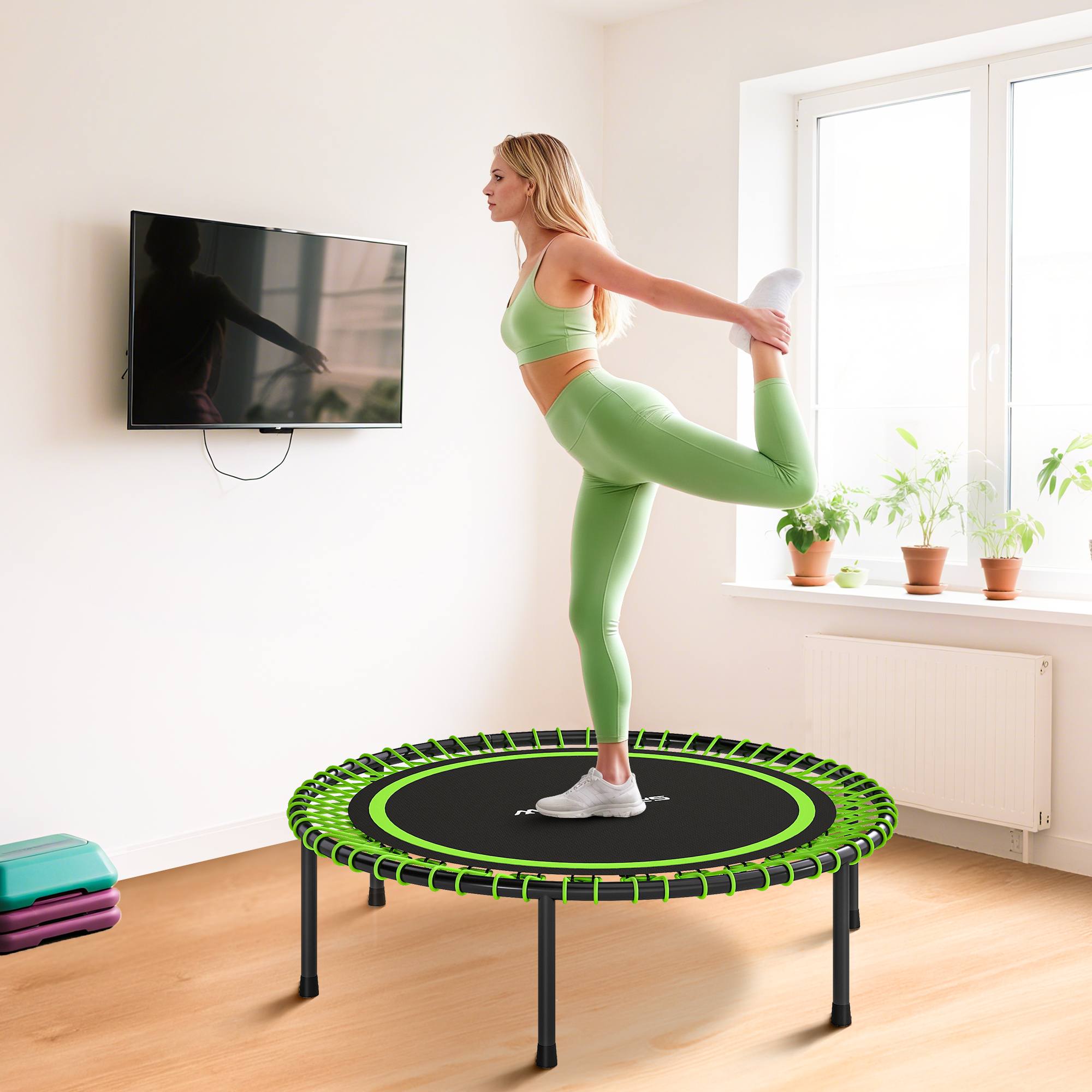 Una mujer con ropa deportiva verde se estira en una cama elástica.