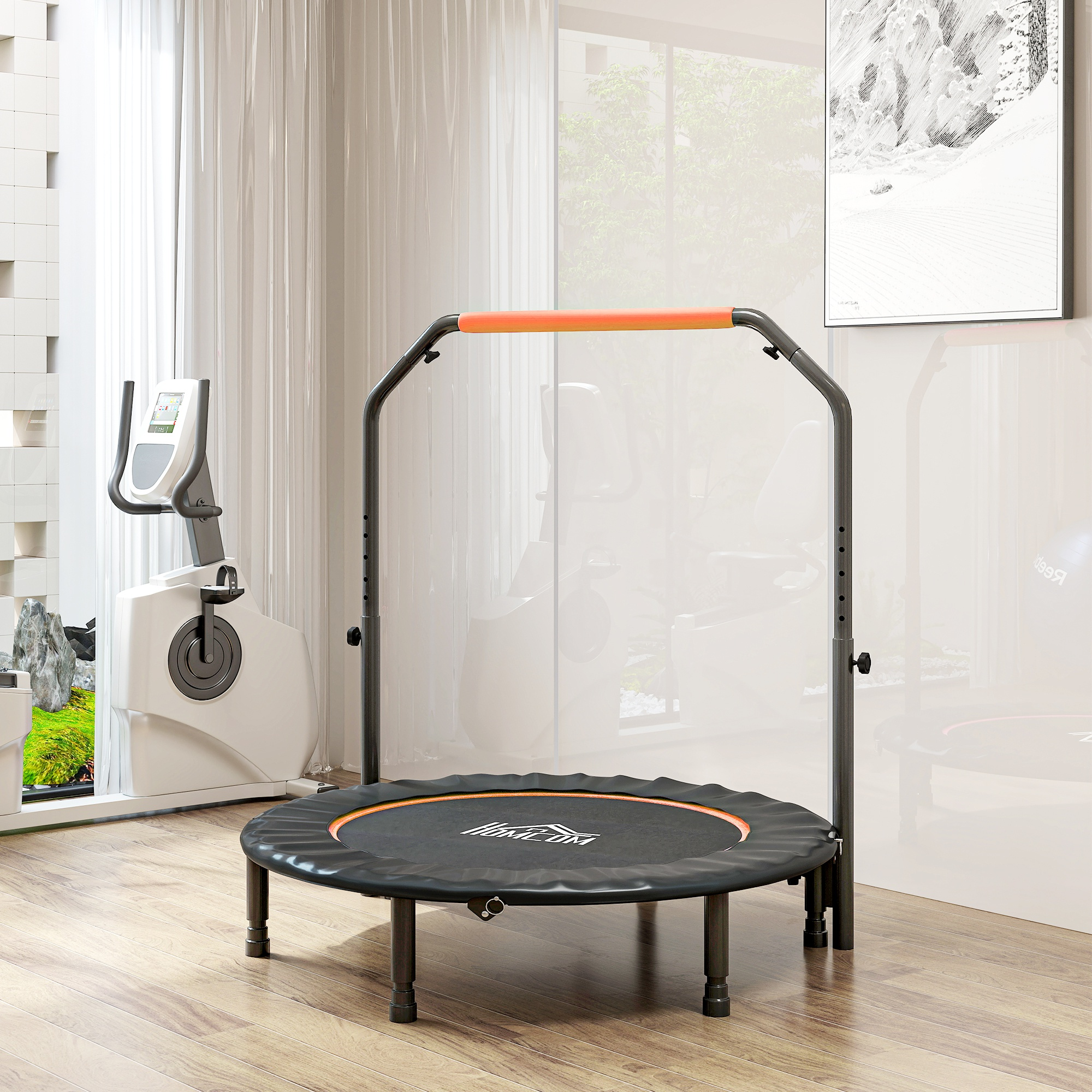 Una cama elástica negra con asa naranja frente a una bicicleta estática.