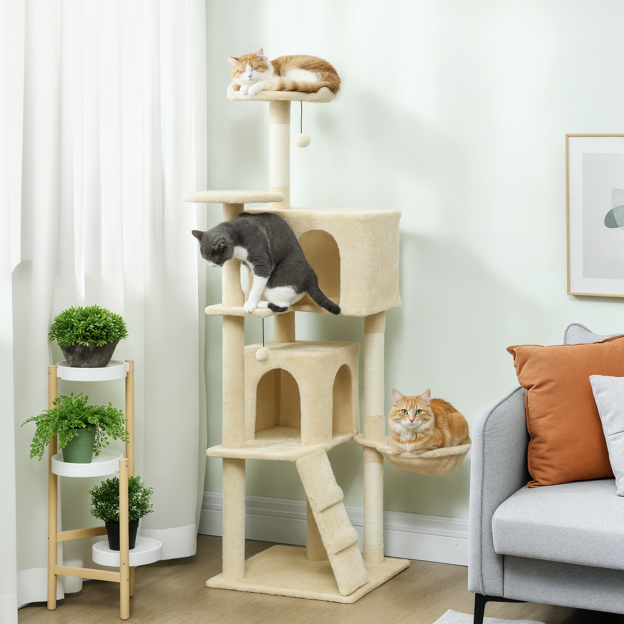 Un árbol rascador beige con tres gatos: uno naranja arriba, uno gris en medio, uno naranja abajo.