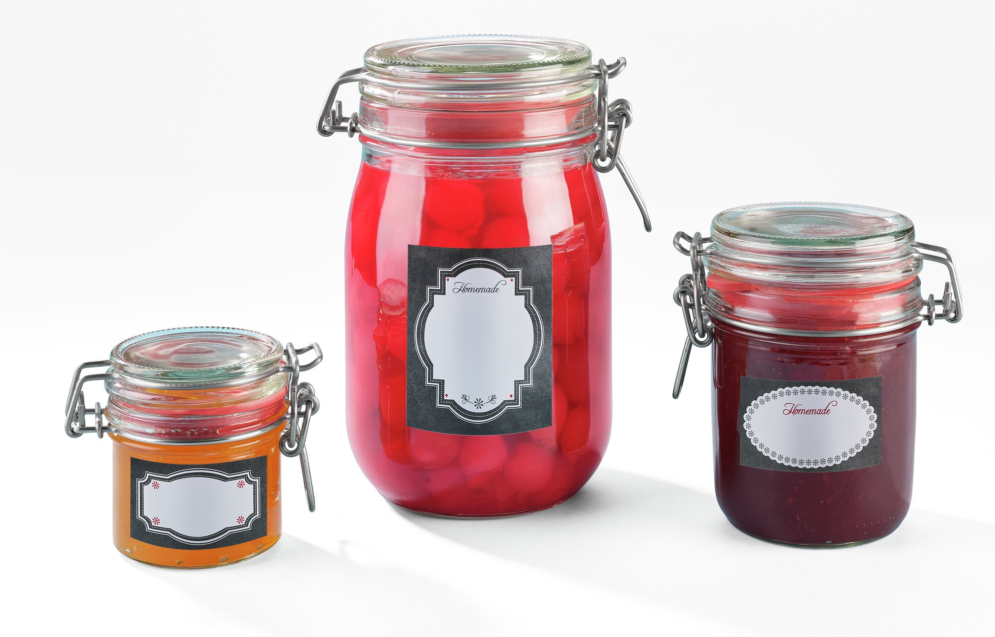 Drei Gläser mit selbstgemachten Konserven: Orange, rote Früchte und Beerenmarmelade.