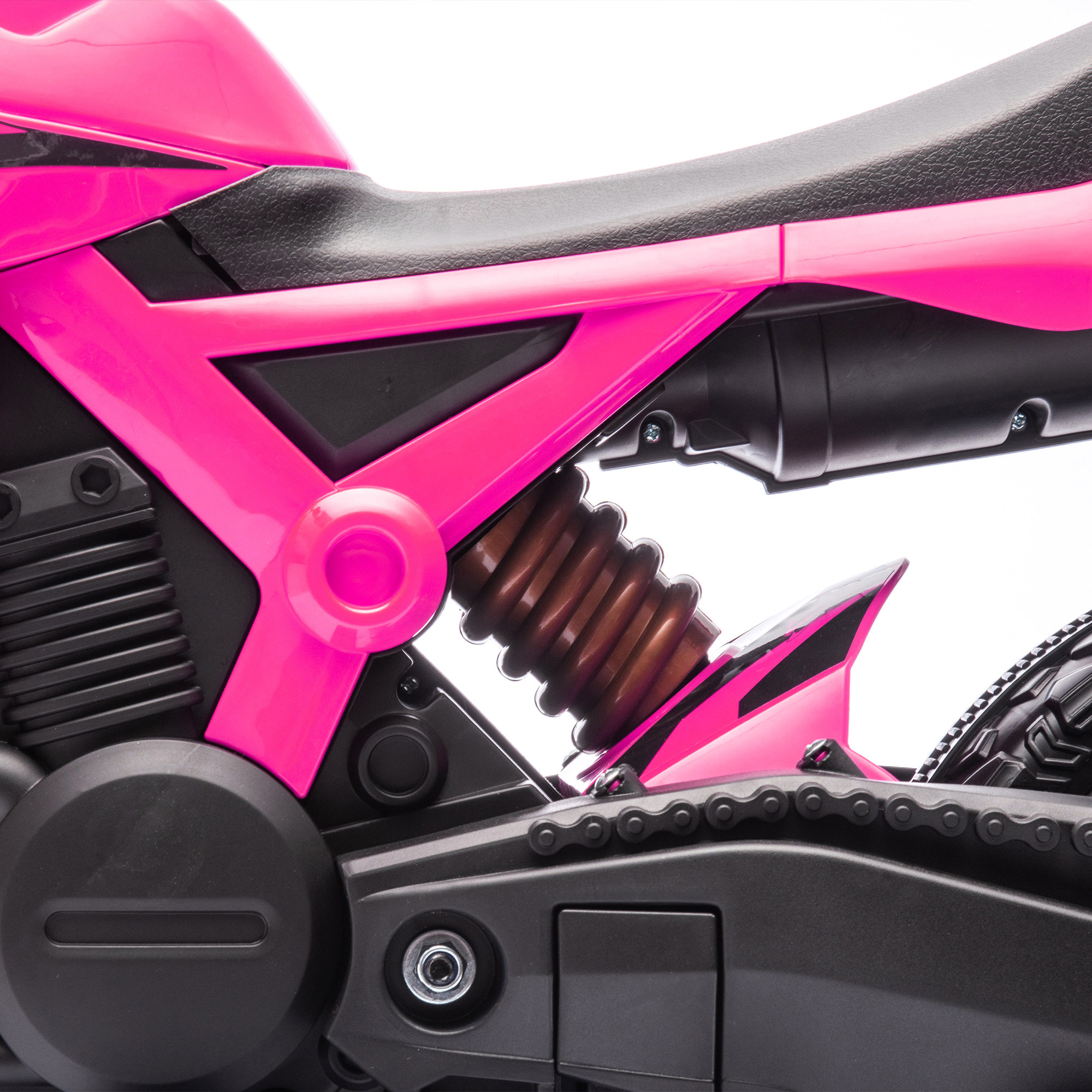 Detalle de motocicleta rosa con asiento negro, amortiguador y cadena.