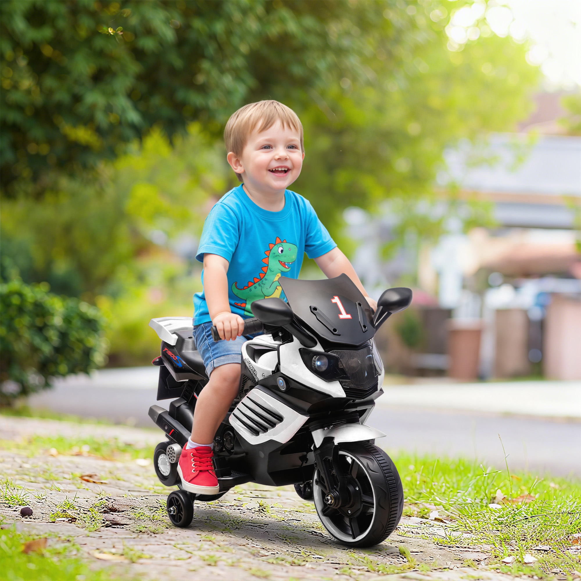 Un niño pequeño monta una motocicleta de juguete por un camino pavimentado al aire libre.
