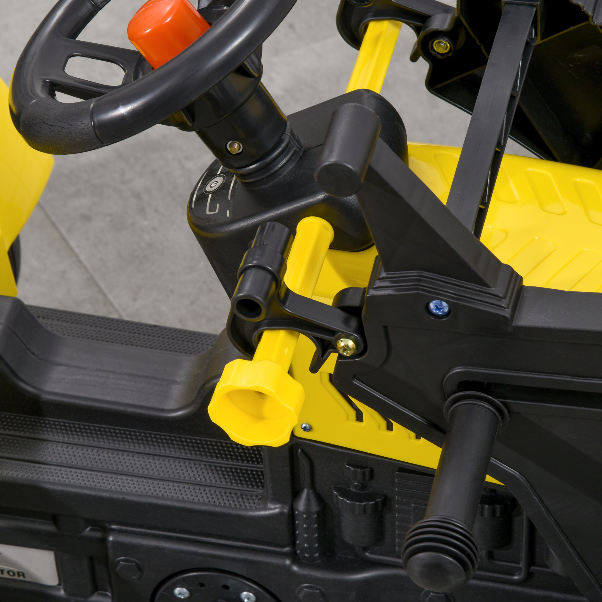 Primer plano de un go-kart infantil amarillo y negro, mostrando el volante y el manillar.