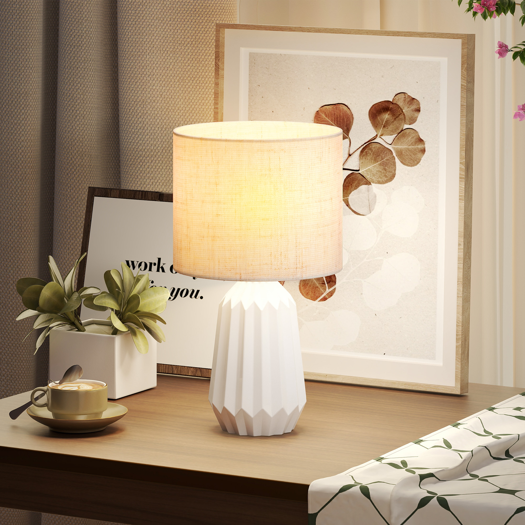 Una base de lámpara blanca con pantalla color crema sobre una mesa de madera.