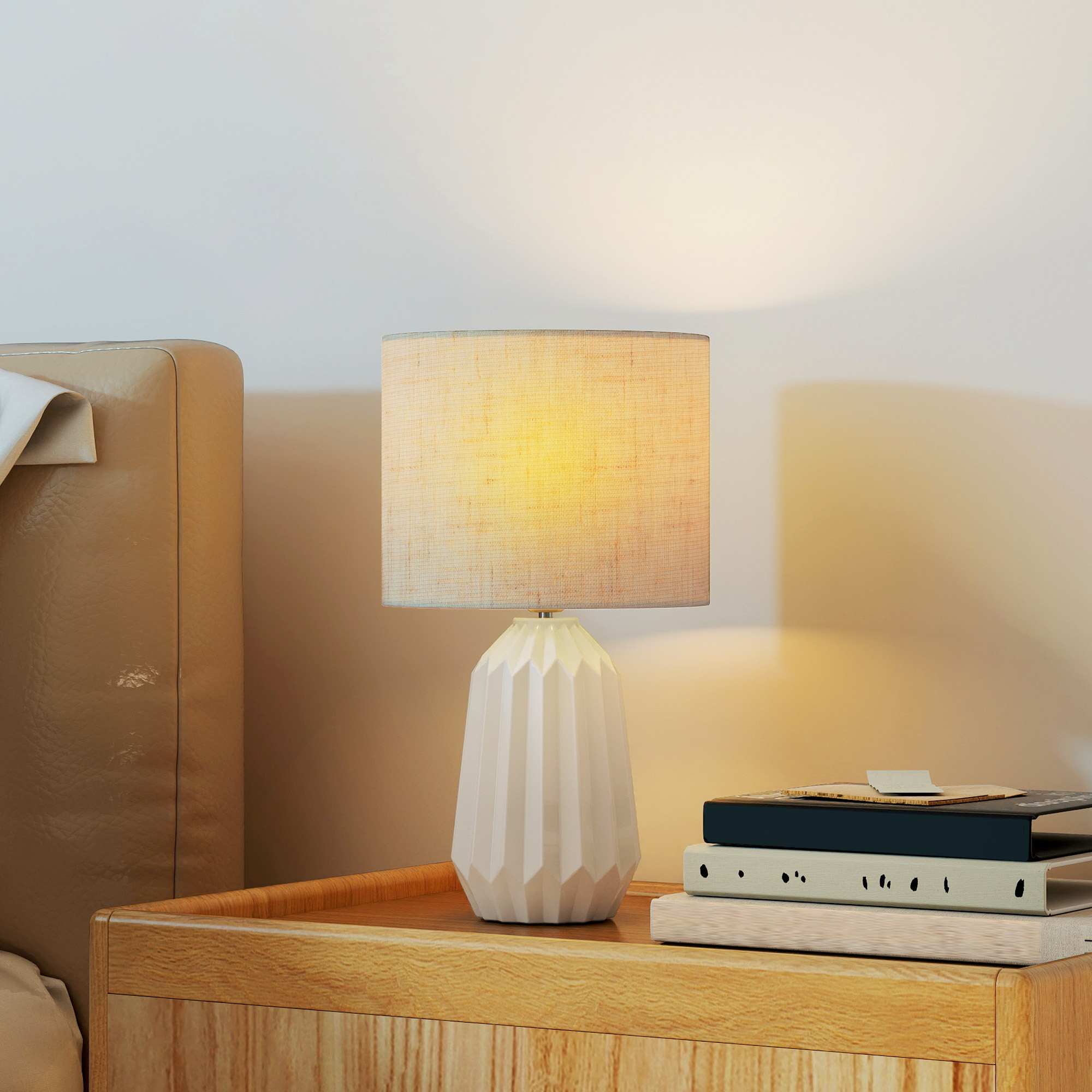 Una mesita de noche de madera con una lámpara y libros.
